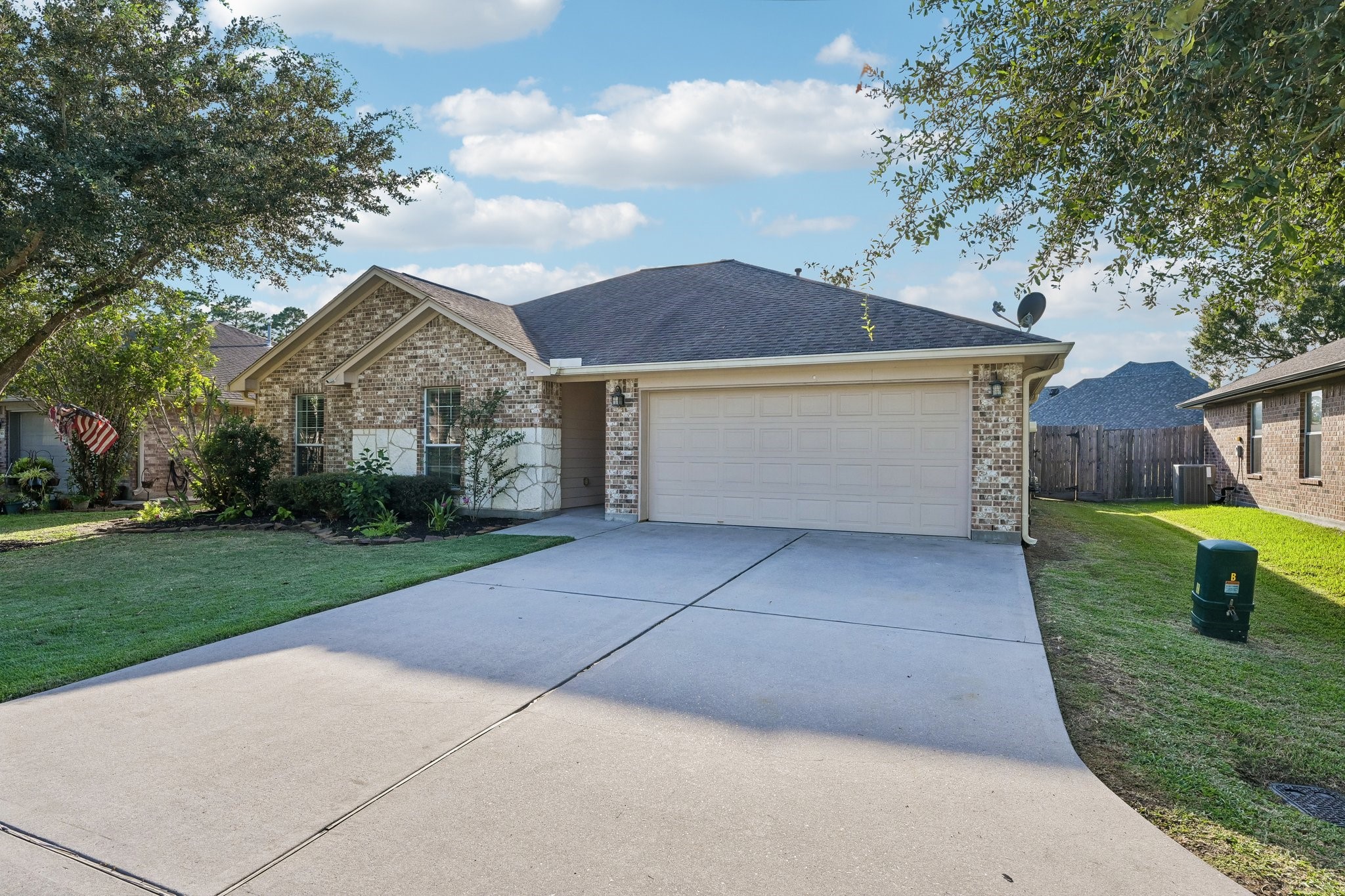 Charming single-story home with a brick exterior, manicured front yard, and a spacious two-car garage, nestled in a peaceful neighborhood.