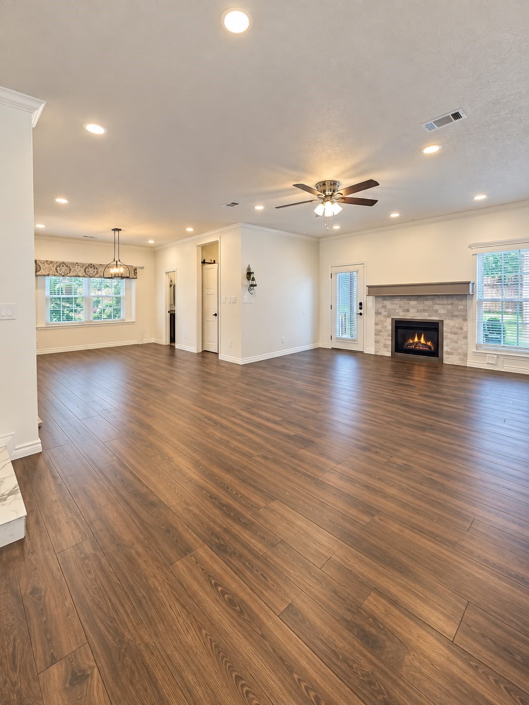 Open layout showcasing the kitchen, breakfast area, and adjoining living space with modern flooring.