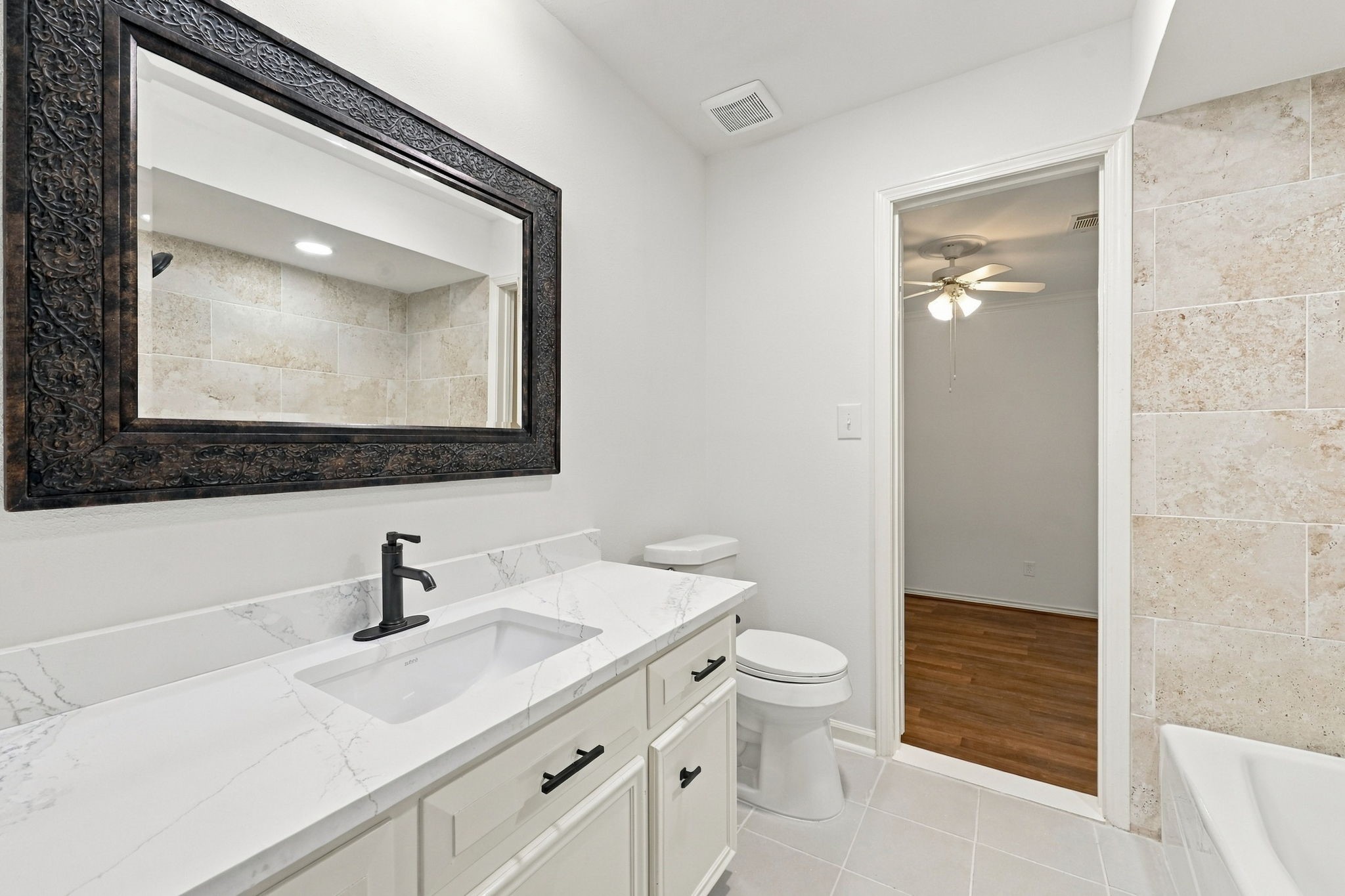Contemporary bathroom with dual vessel sinks, a teal vanity, elegant mirrors, and a spacious walk-in shower.