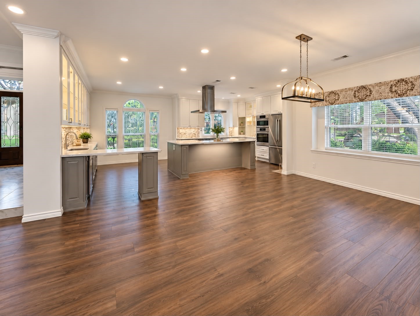 Expansive kitchen with generous counter space, a central island, stainless steel appliances, and open living areas.