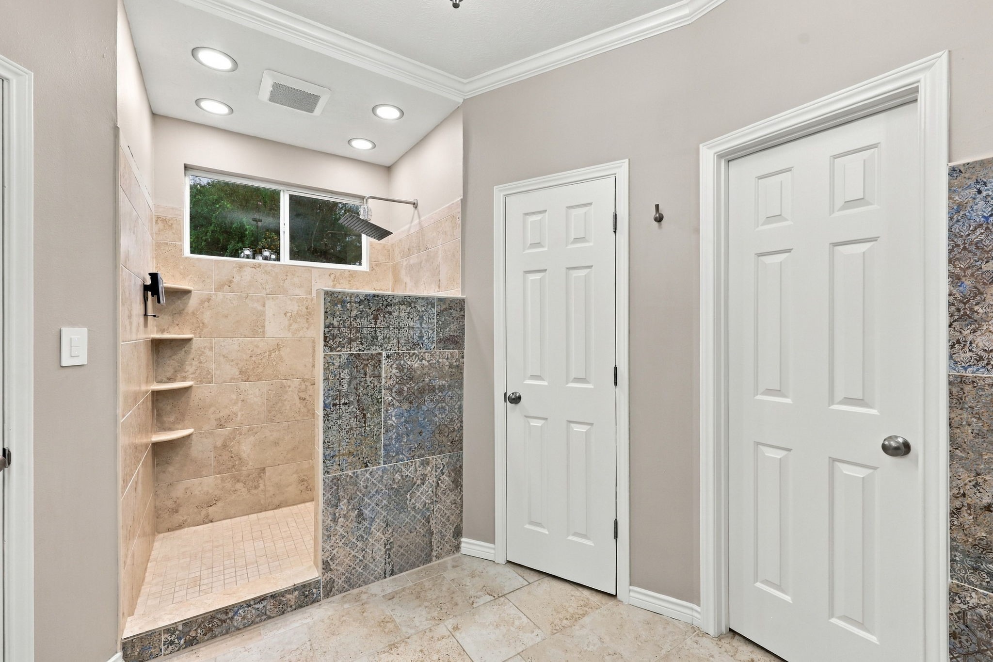 Contemporary bathroom with dual vessel sinks, a teal vanity, elegant mirrors, and a spacious walk-in shower.