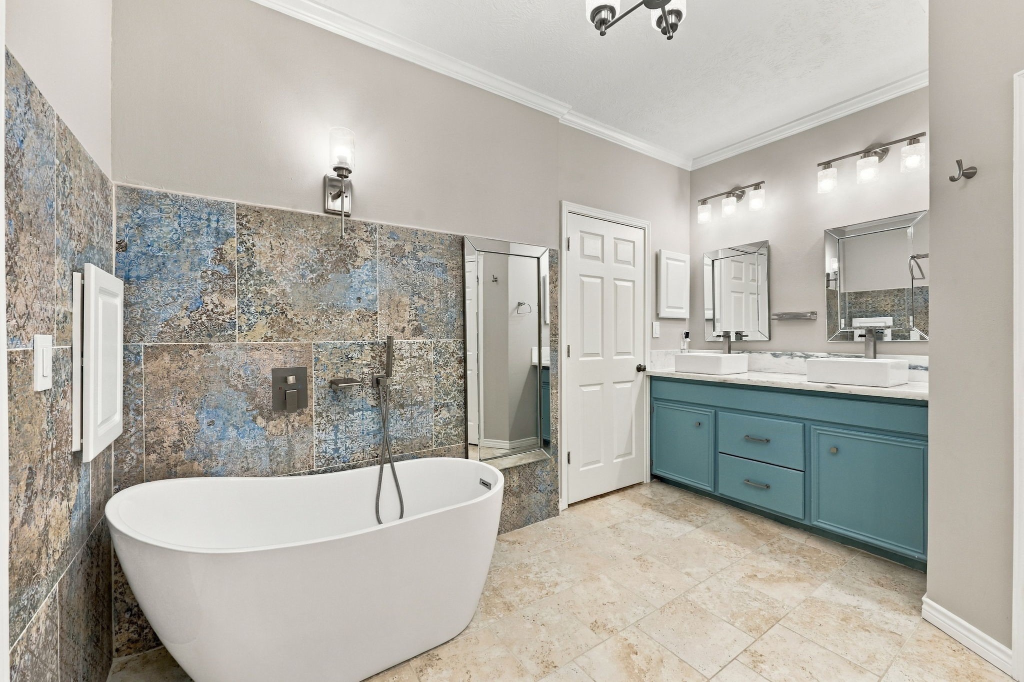 Primary bathroom featuring a freestanding soaking tub, decorative tile accents, and a separate glass-enclosed shower.