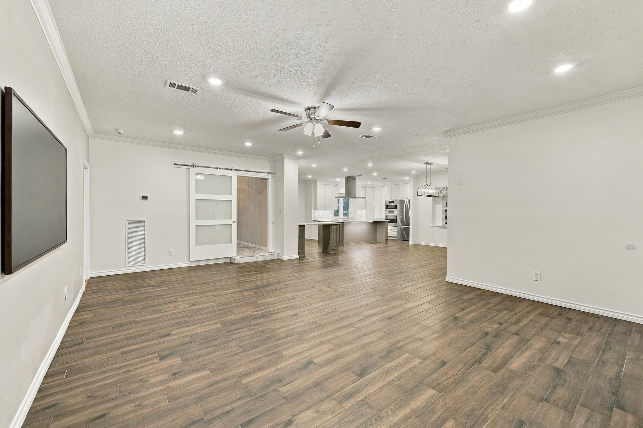 Open living area offering generous floor space, neutral finishes, and convenient access to the kitchen.