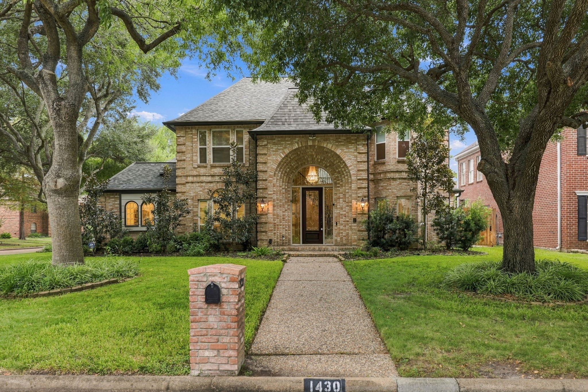 Attractive two-story brick faade with a welcoming walkway, arched entry, and established landscaping. Attractive two-story brick faade with a welcoming walkway, arched entry, and established landscaping.