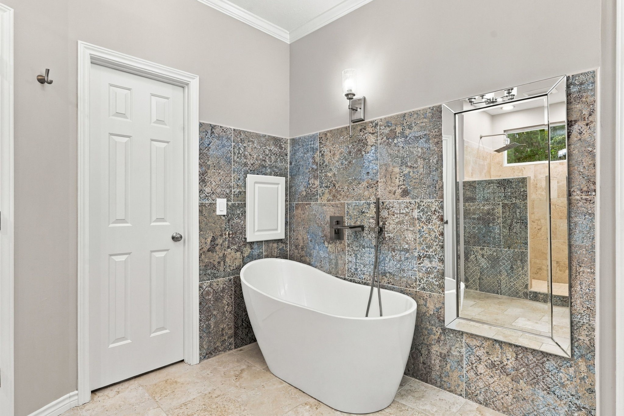 Primary bathroom featuring a freestanding soaking tub, decorative tile accents, and a separate glass-enclosed shower.