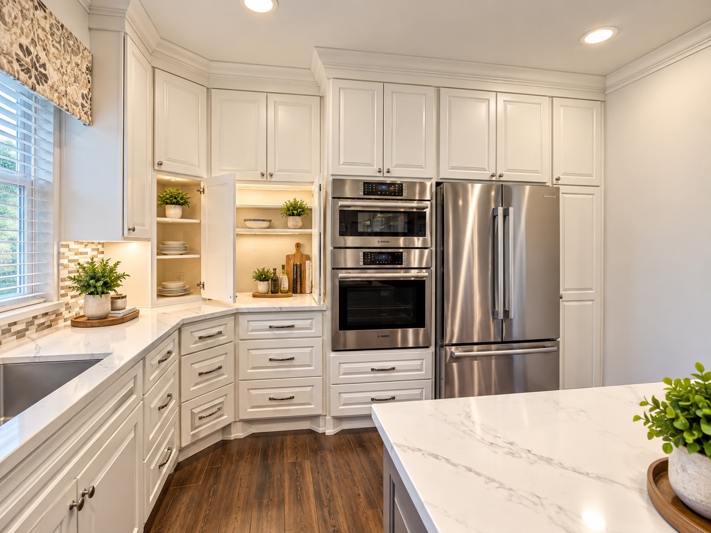 Kitchen sink positioned beneath elegant arched windows, complemented by white cabinetry and stone countertops.