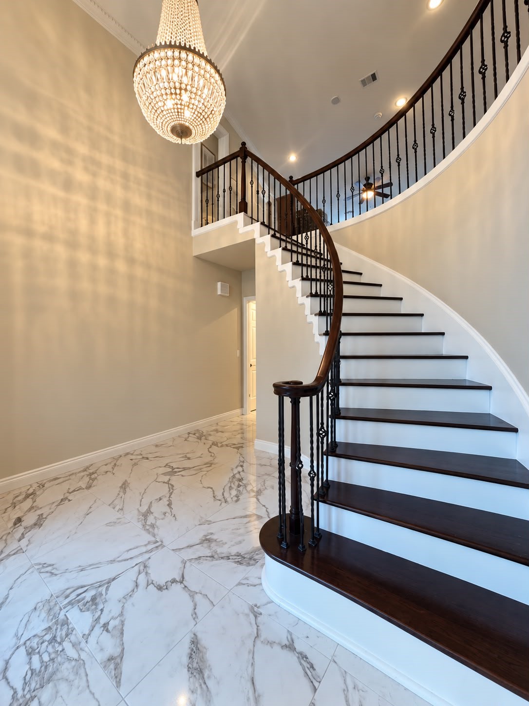 Bright entryway showcasing a curved staircase, elegant railing, and a spacious adjoining area. Bright entryway showcasing a curved staircase, elegant railing, and a spacious adjoining area.