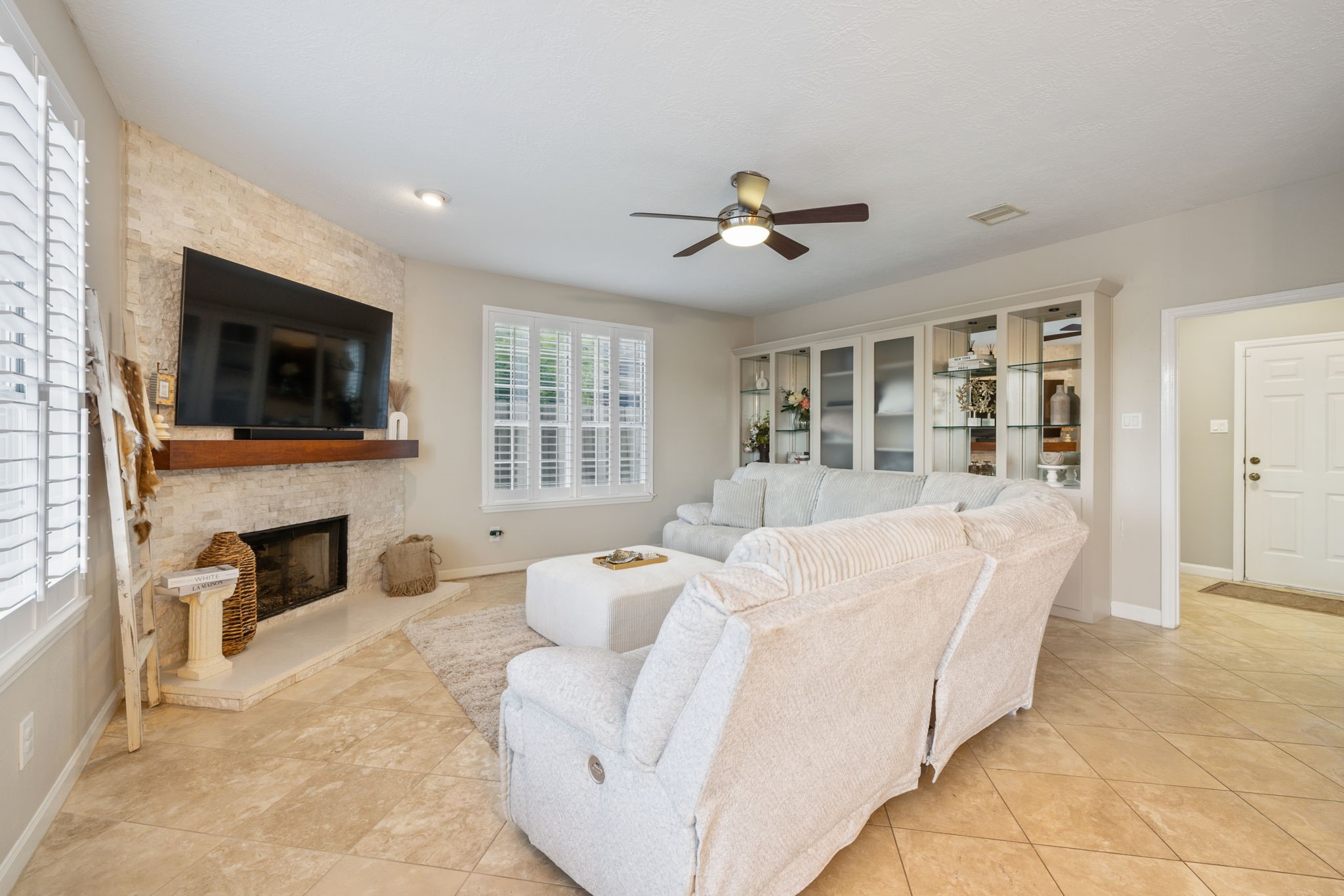 Inviting living room anchored by a stunning stone fireplace and complemented by custom built-ins.