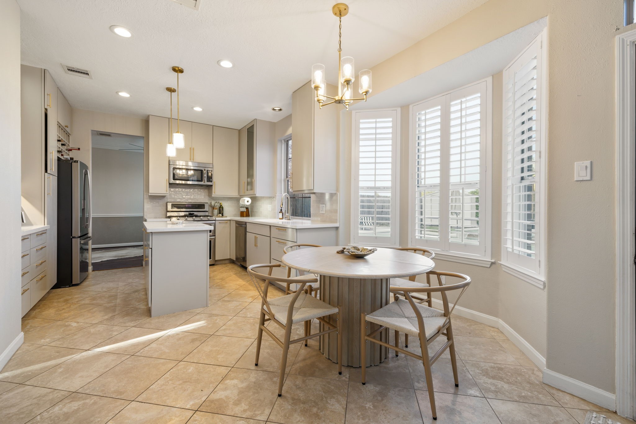 Sunlit breakfast area with plantation shutters and seamless access to the elegantly updated kitchen.