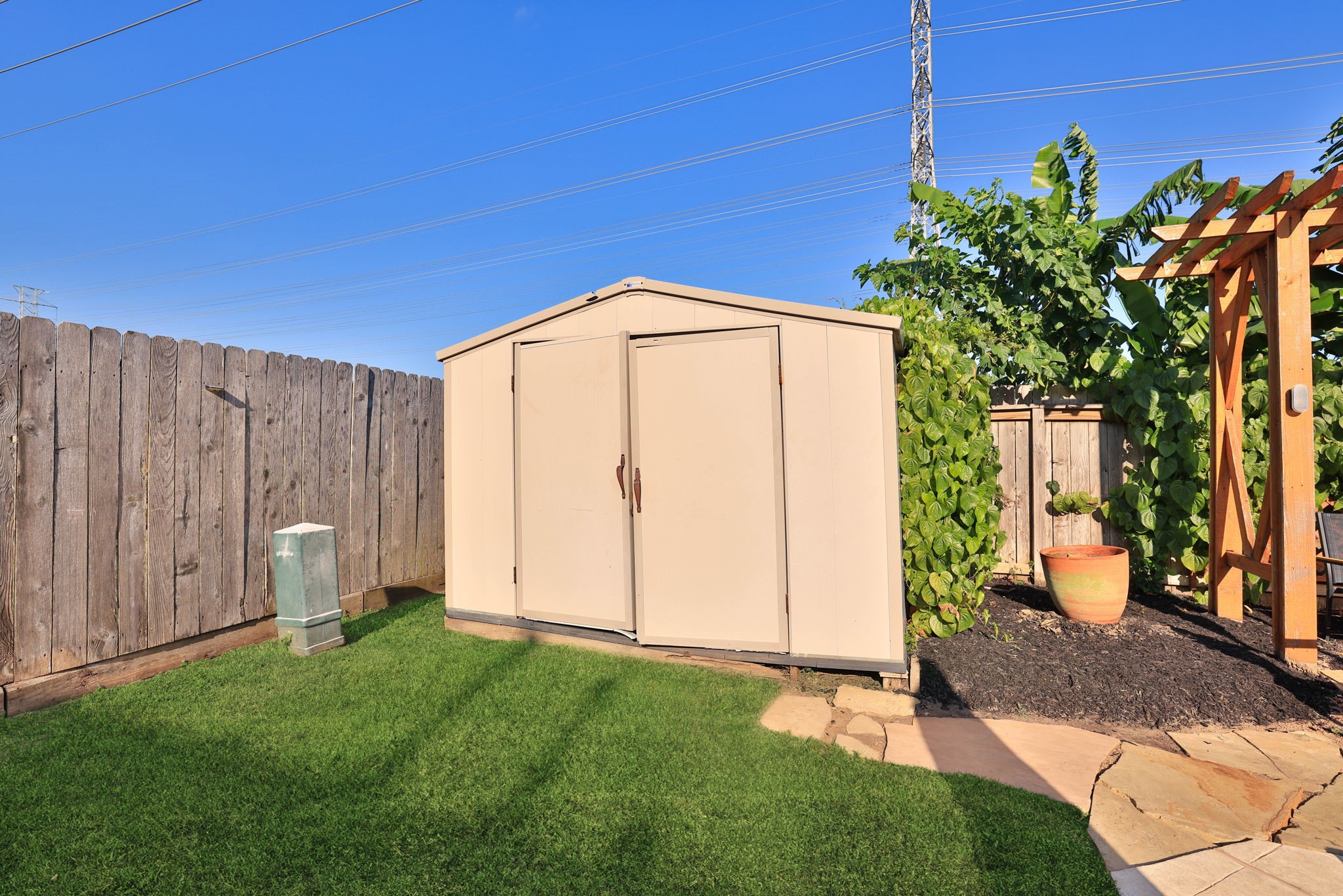 Convenient backyard storage shed provides additional space for pool equipment, lawn care essentials, and outdoor accessories.