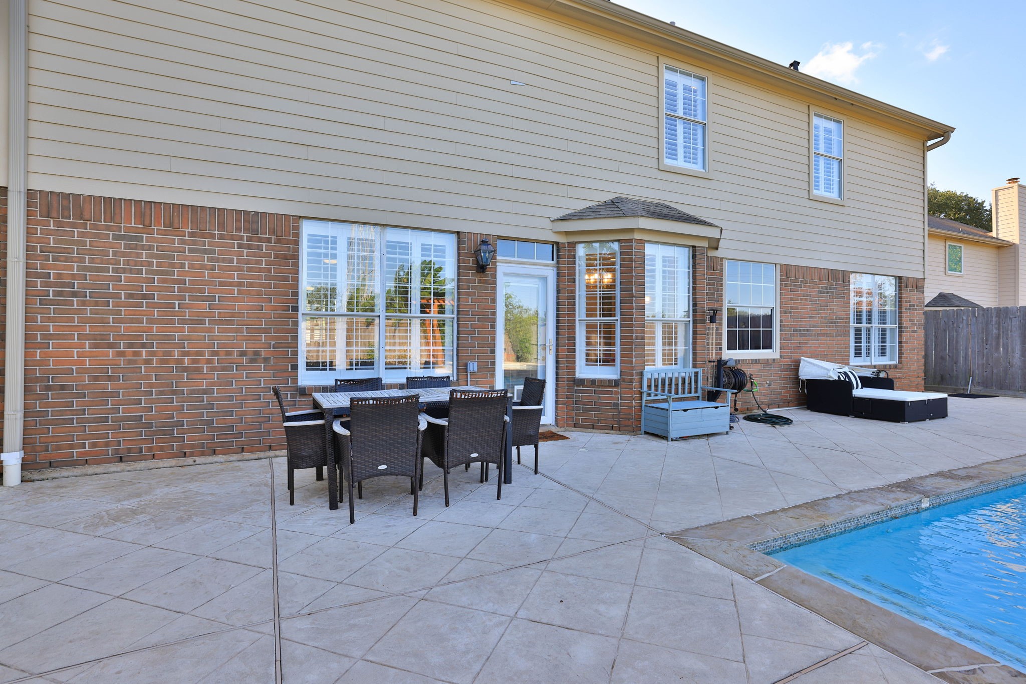 Expansive patio offers plenty of room for outdoor dining, lounging, ad entertaining alongside the sparkling pool.