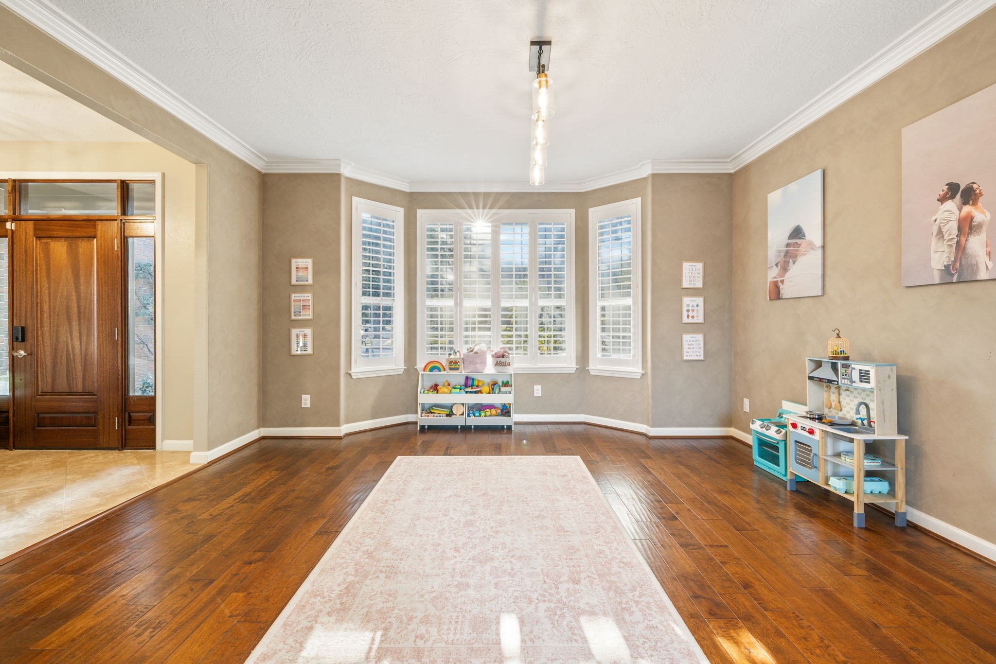 Rich hardwood floors, crown molding, and a beautiful bay window with plantation shutters enhance this versatile dining space. Rich hardwood floors, crown molding, and a beautiful bay window with plantation shutters enhance this versatile dining space.