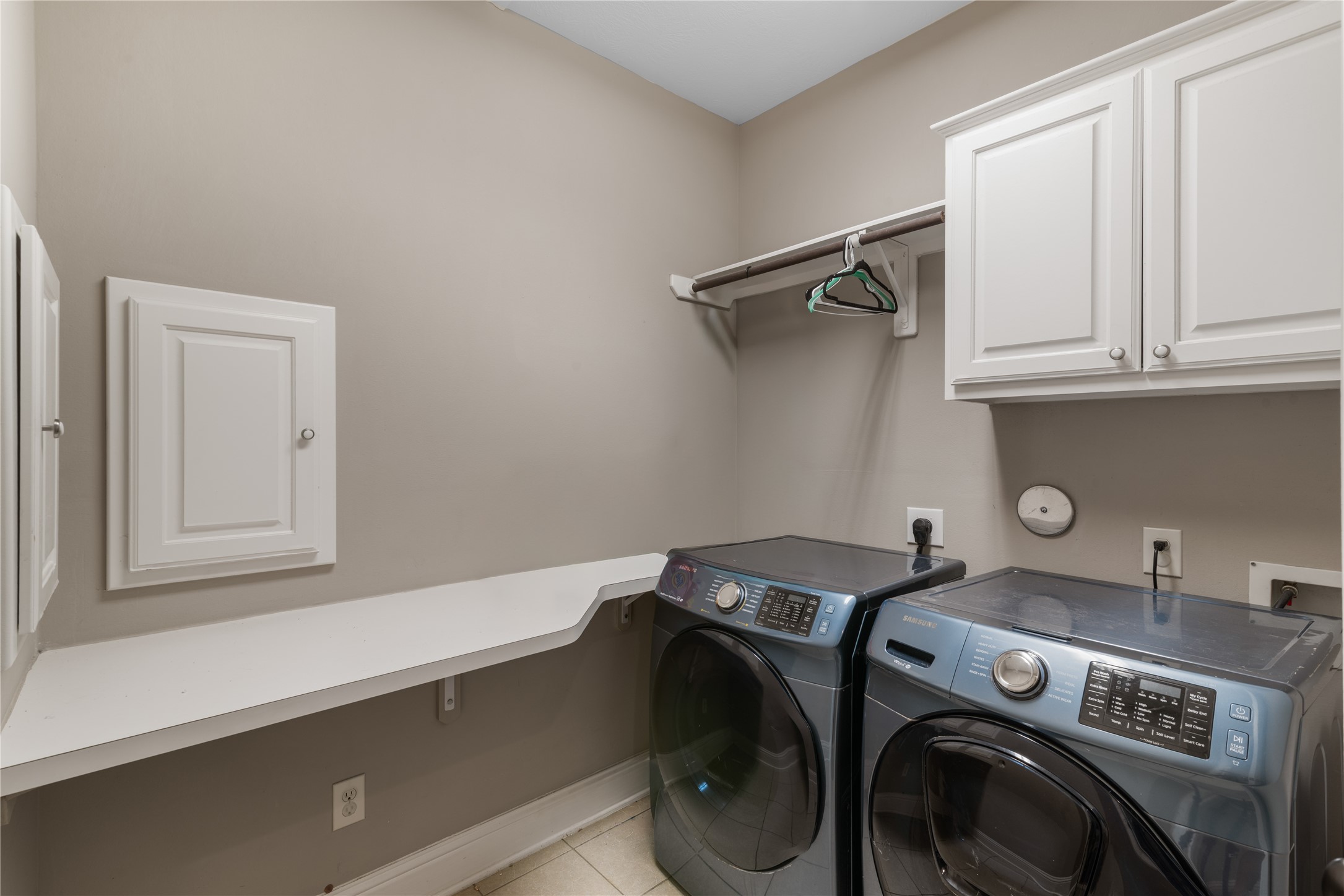 Well-appointed utility room with upper cabinetry for storage, functional counter space and laundry shoots from the master bedroom behind those doors on the left.