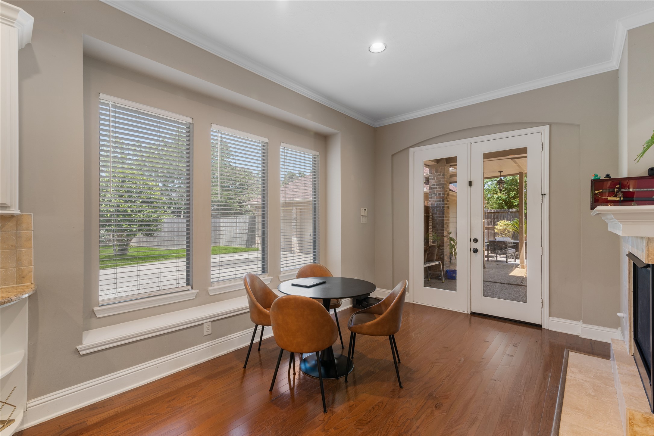 The breakfast nook sits beside large windows and glass door overlooking the backyard and pool.