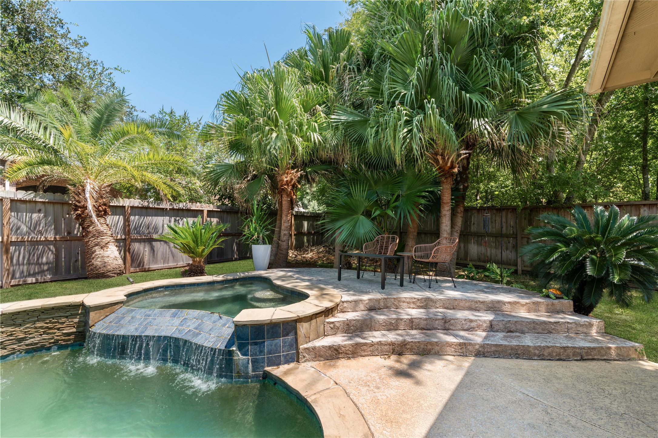 Tropical backyard oasis with pool and hot tub.
