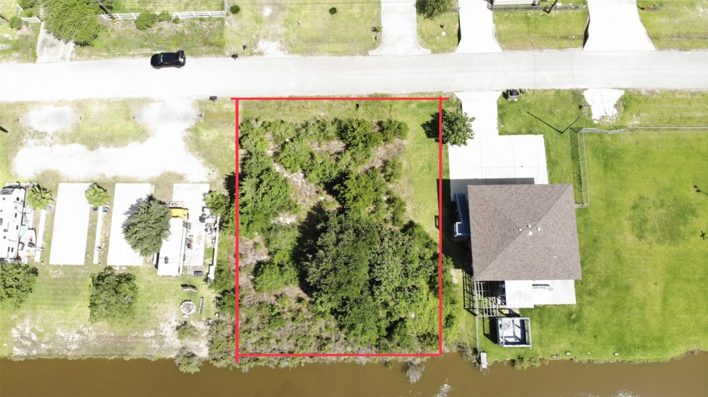 Aerial view shows a lot outlined in red, offering potential for development in a quiet residential area. Aerial view shows a lot outlined in red, offering potential for development in a quiet residential area.