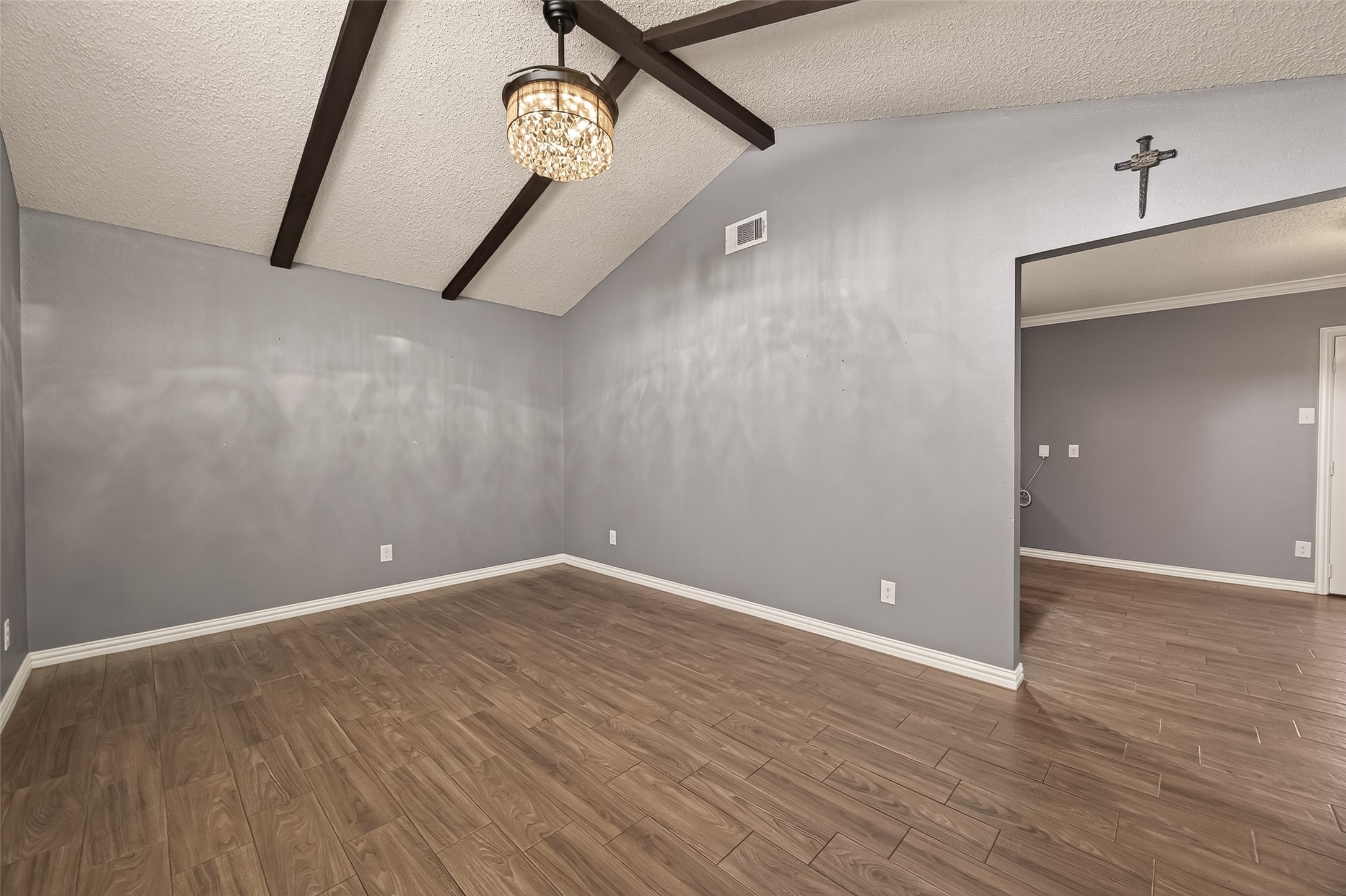 The living room showcases dramatic vaulted ceilings with exposed beams, updated lighting, and low-maintenance wood-look flooring, offering both character and comfort. The living room showcases dramatic vaulted ceilings with exposed beams, updated lighting, and low-maintenance wood-look flooring, offering both character and comfort.