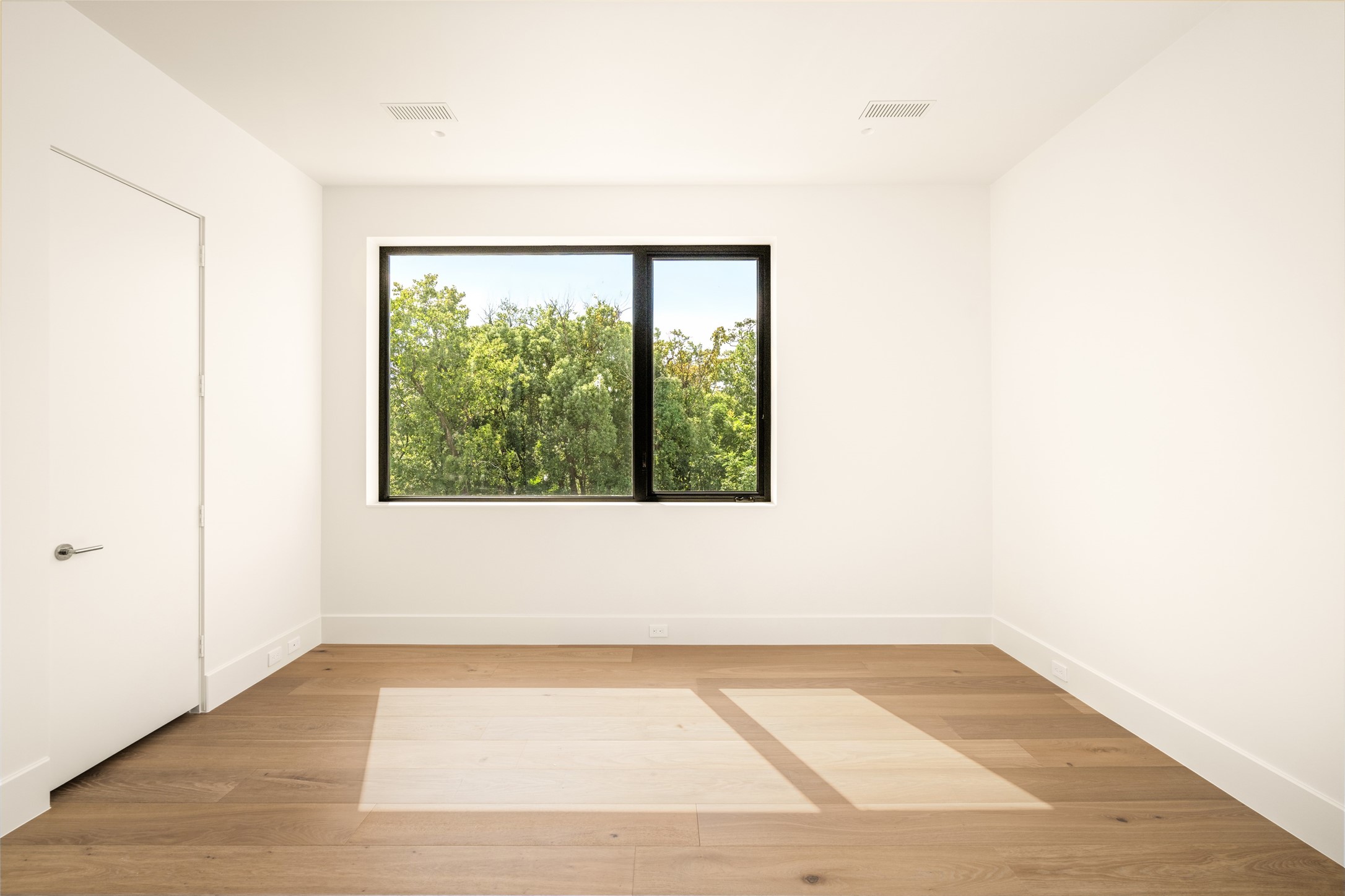 This comfortable bedroom suite offers a versatile layout, a generous closet, and serene treetop views through a a large picture window.