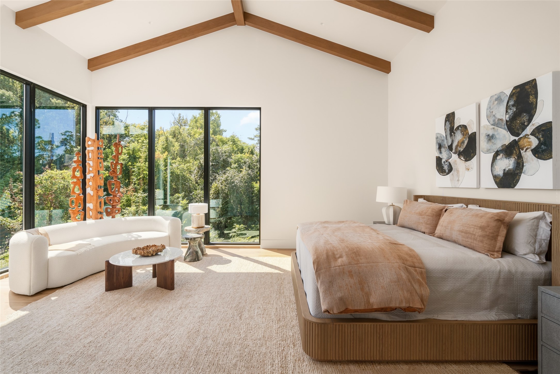 Soft Venetian plaster walls and warm, natural finishes bring understated elegance to this generously proportioned bedroom, with a dedicated sitting area offering a comfortable place to unwind.