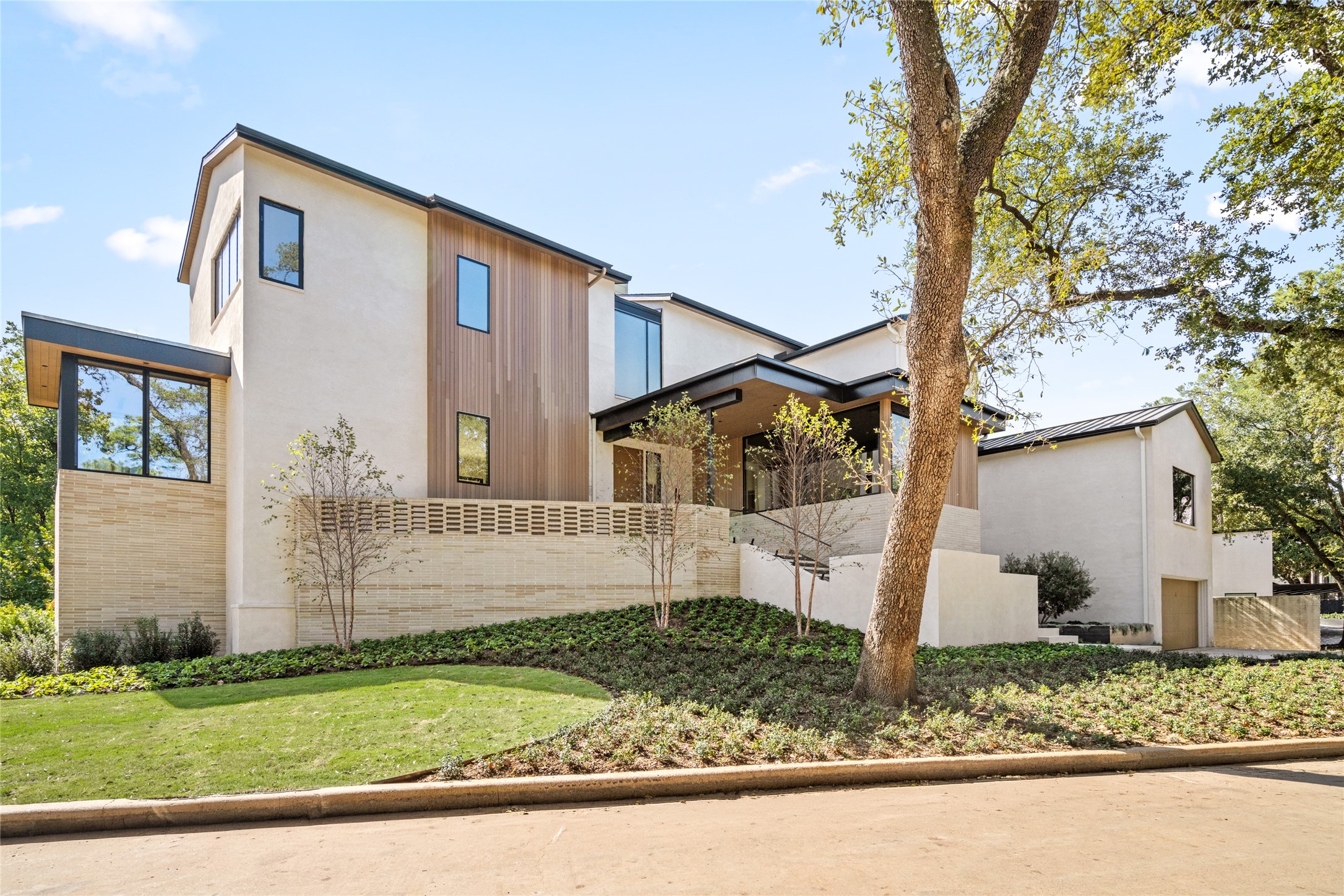 Nestled in a lush, green setting on Tiel Way, this newly constructed River Oaks estate pairs striking architectural lines, expansive glass, and warm wood accents with sophisticated contemporary design.