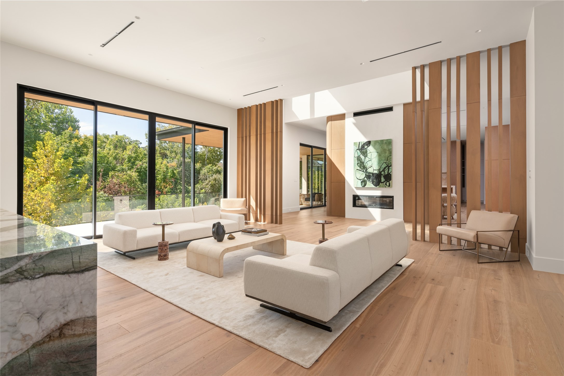 Sculptural white oak partitions bring warmth and architectural interest to this spacious entertaining lounge, subtly defining the seating area while maintaining an open, airy feel throughout.