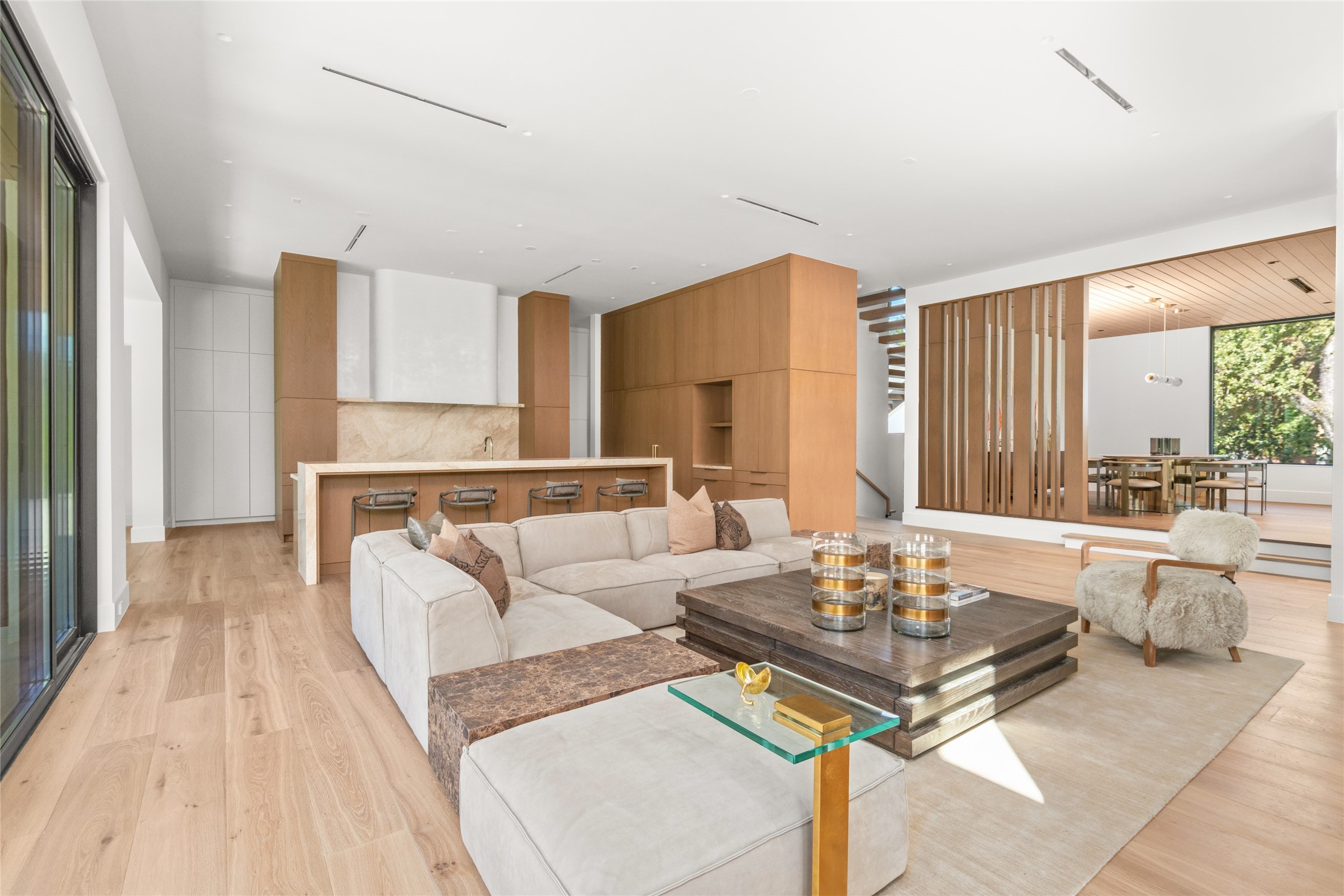 This perspective brings the family room, chefs kitchen, and elevated dining room together, showcasing the thoughtful arrangement of the home's main living spaces and the ease with which they flow from one to the next.