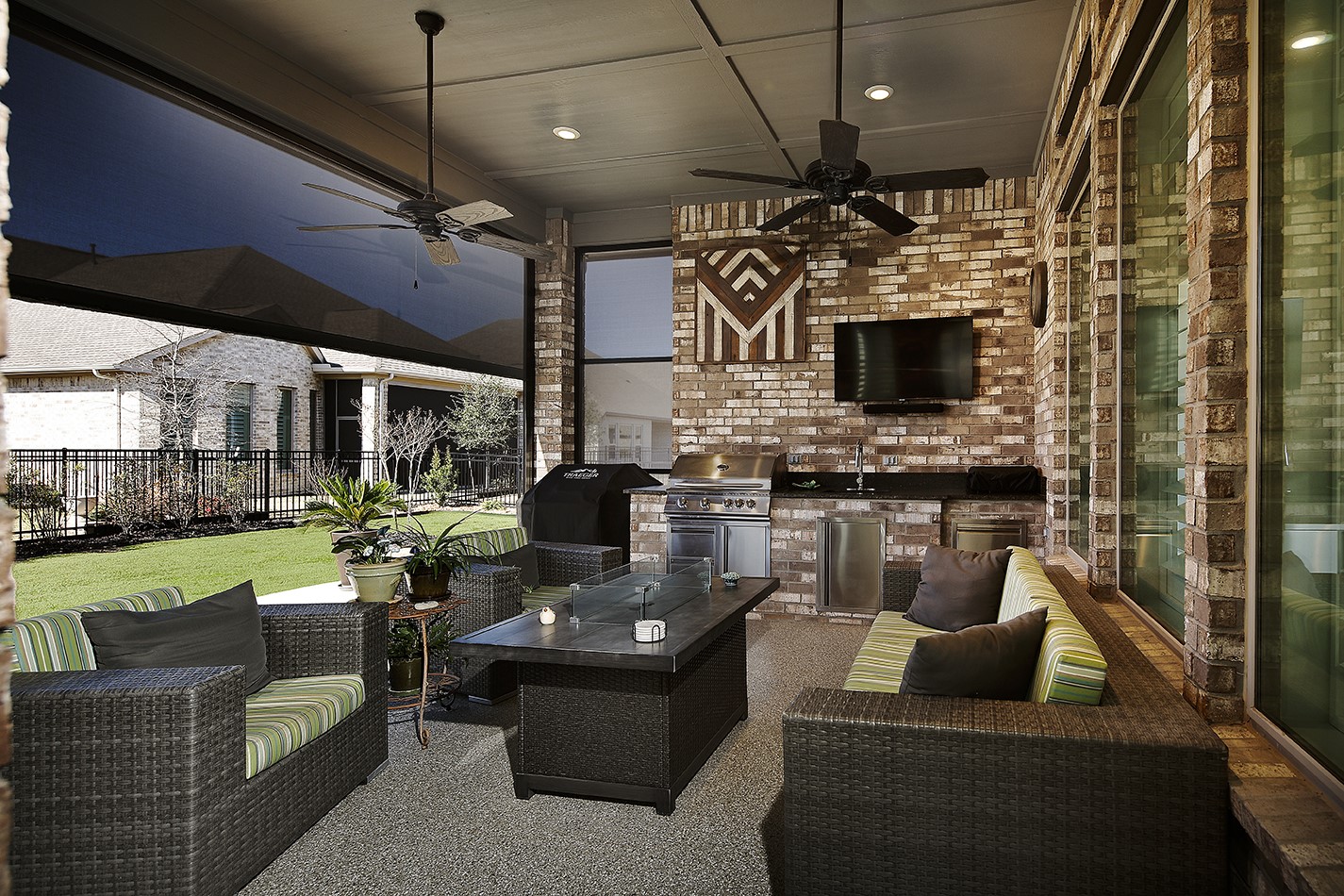 This covered lanai offers a welcoming ambiance, designed for ultimate comfort with electric shades to block the sun and dual ceiling fans.