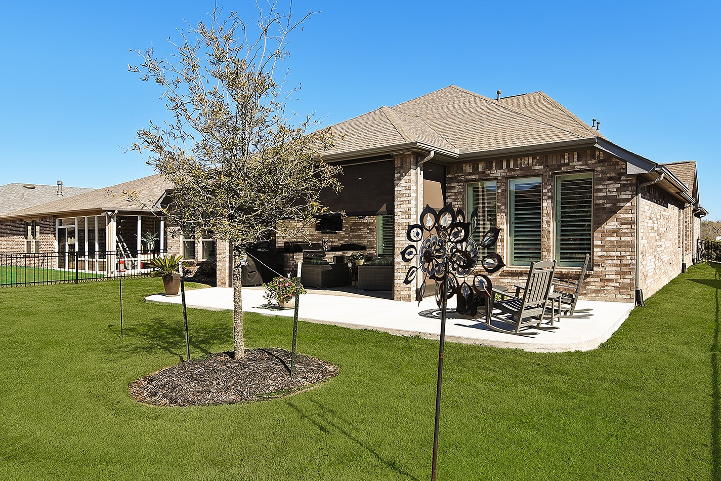 Spacious backyard featuring wrought iron fencing to provide an open, airy feel and unobstructed views.