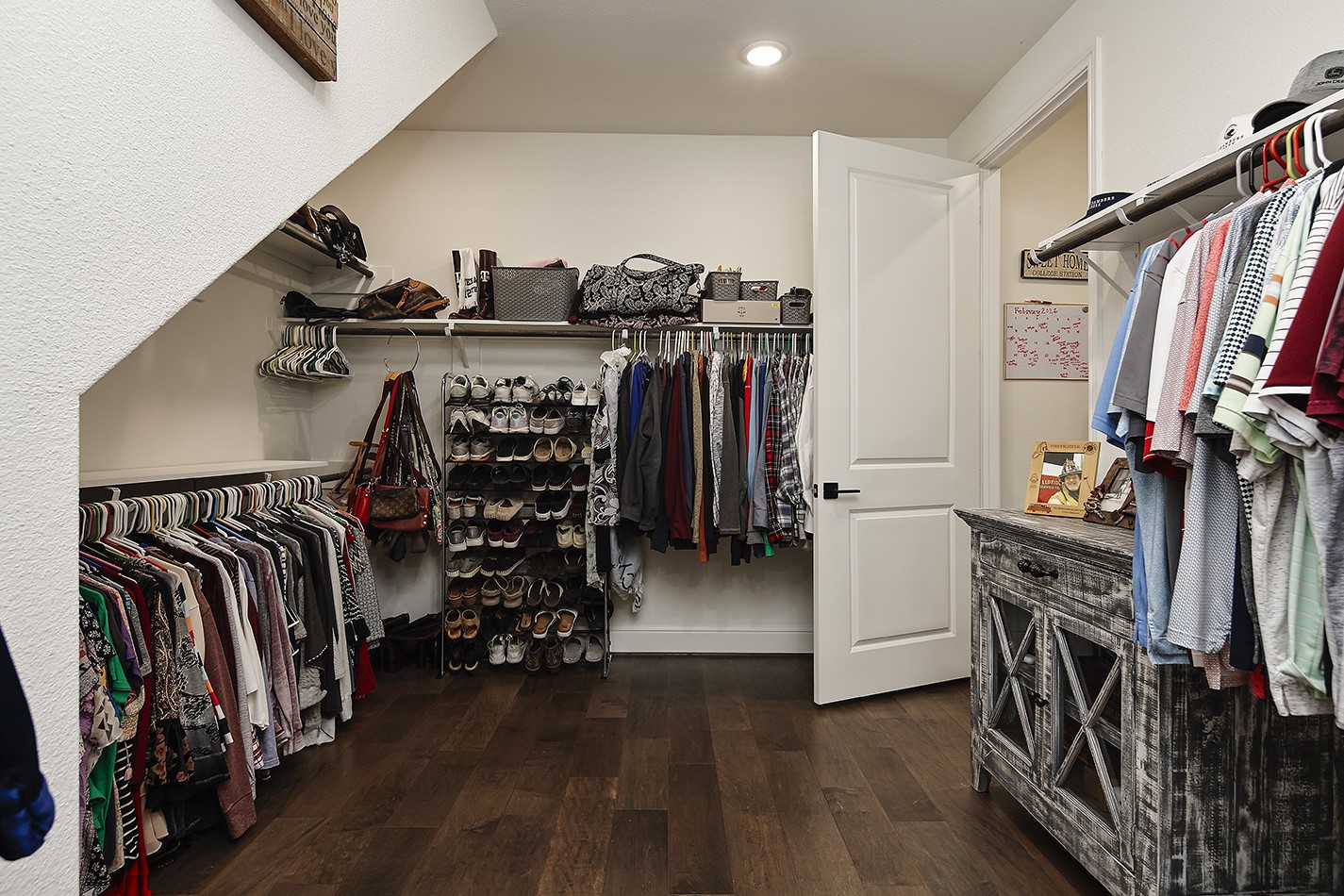 Spacious primary closet has custom built-ins with a place for everything.