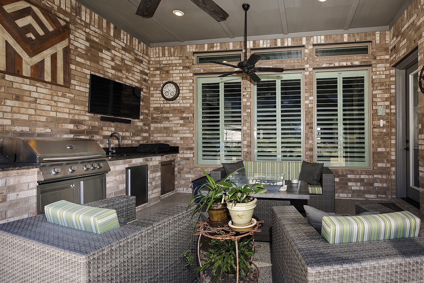 Gorgeous covered lanai featuring a fully equipped outdoor kitchen with a built-in grill and plenty of space for lounge furniture, perfect for outdoor entertaining.