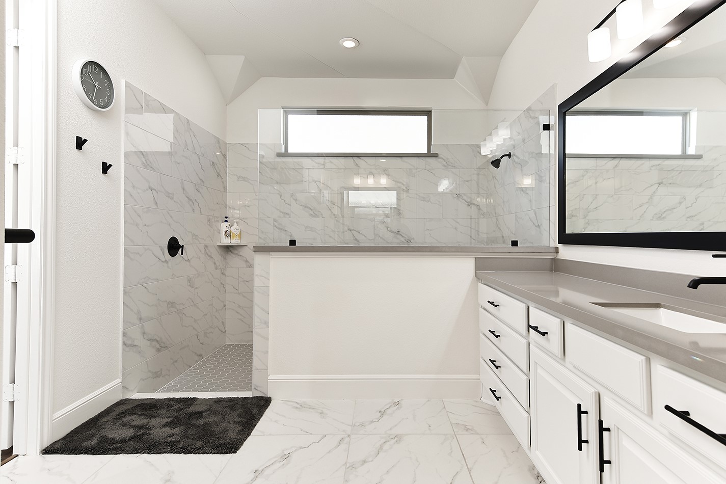 The primary bath has a spacious walk-in shower with glass enclosure and gorgeous marble tile selections.