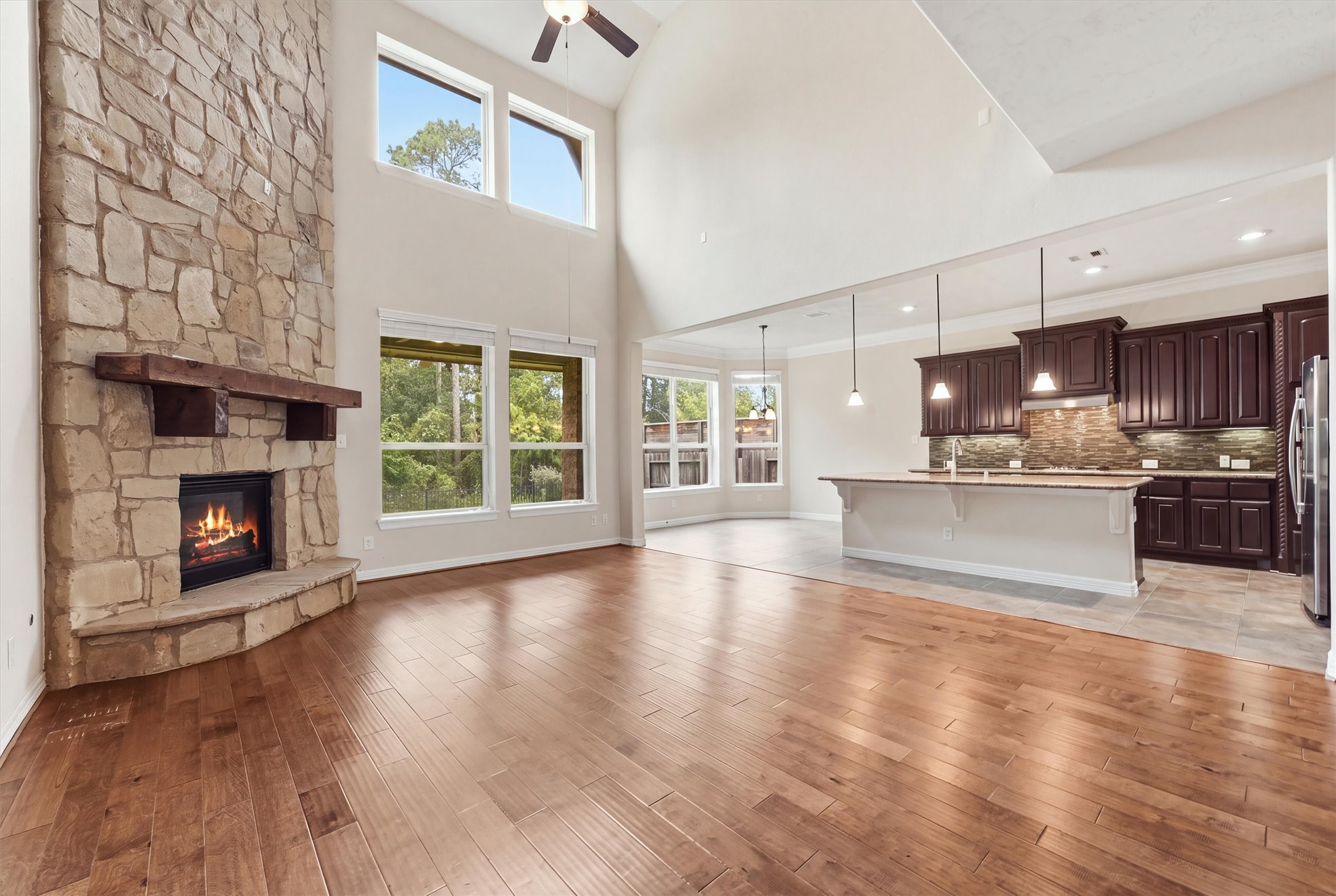 Living room with  floor to ceiling stacked stone fireplace - opens to kitchen and breakfast room beyond