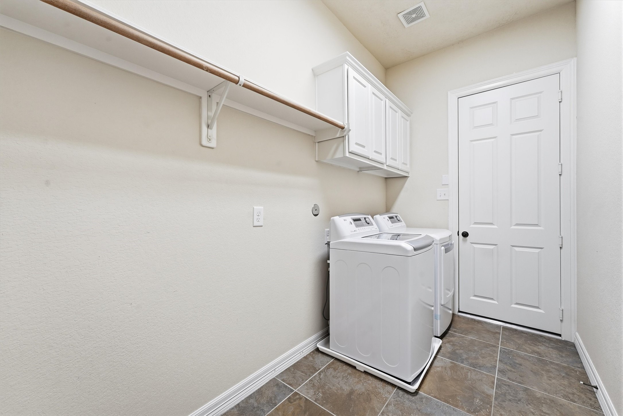 Large laundry room with cabinet storage and extra room for hanging clothes