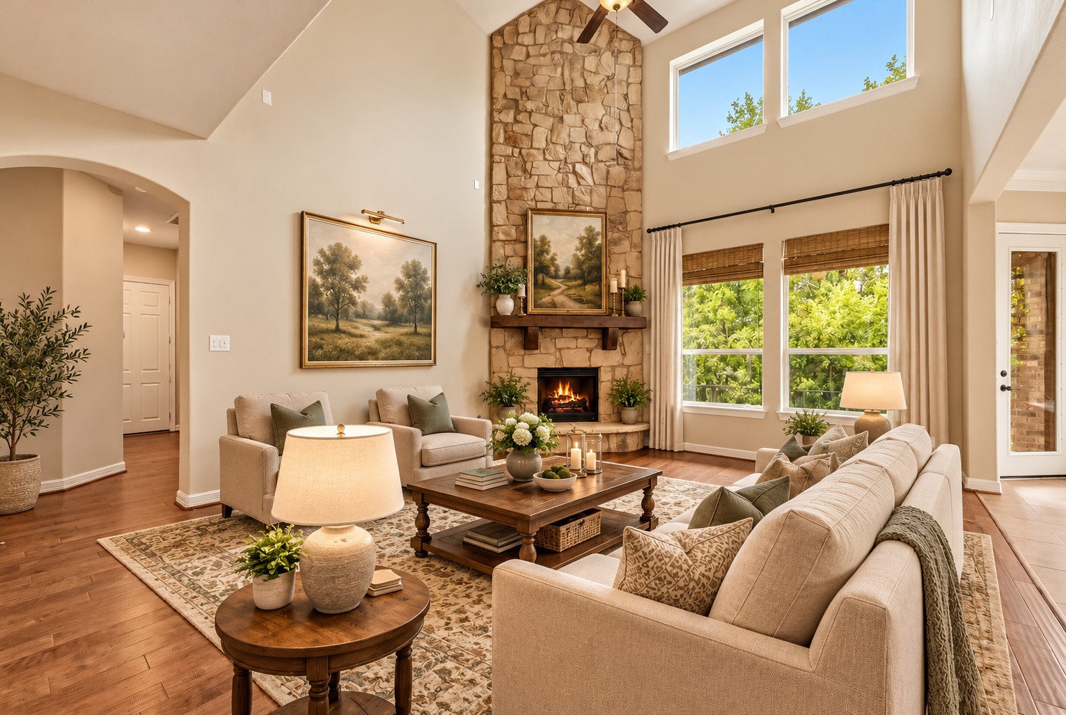 Another view of the living room shown with virtual staging, large windows, floor to ceiling stacked stone fireplace and beautiful wood floors