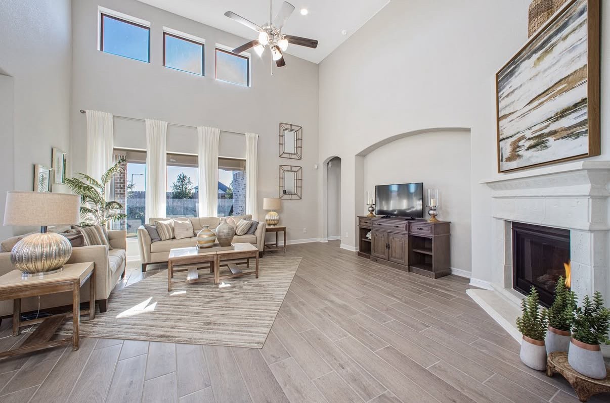 Spacious living room with high ceilings, abundant natural light, and a cozy fireplace.
