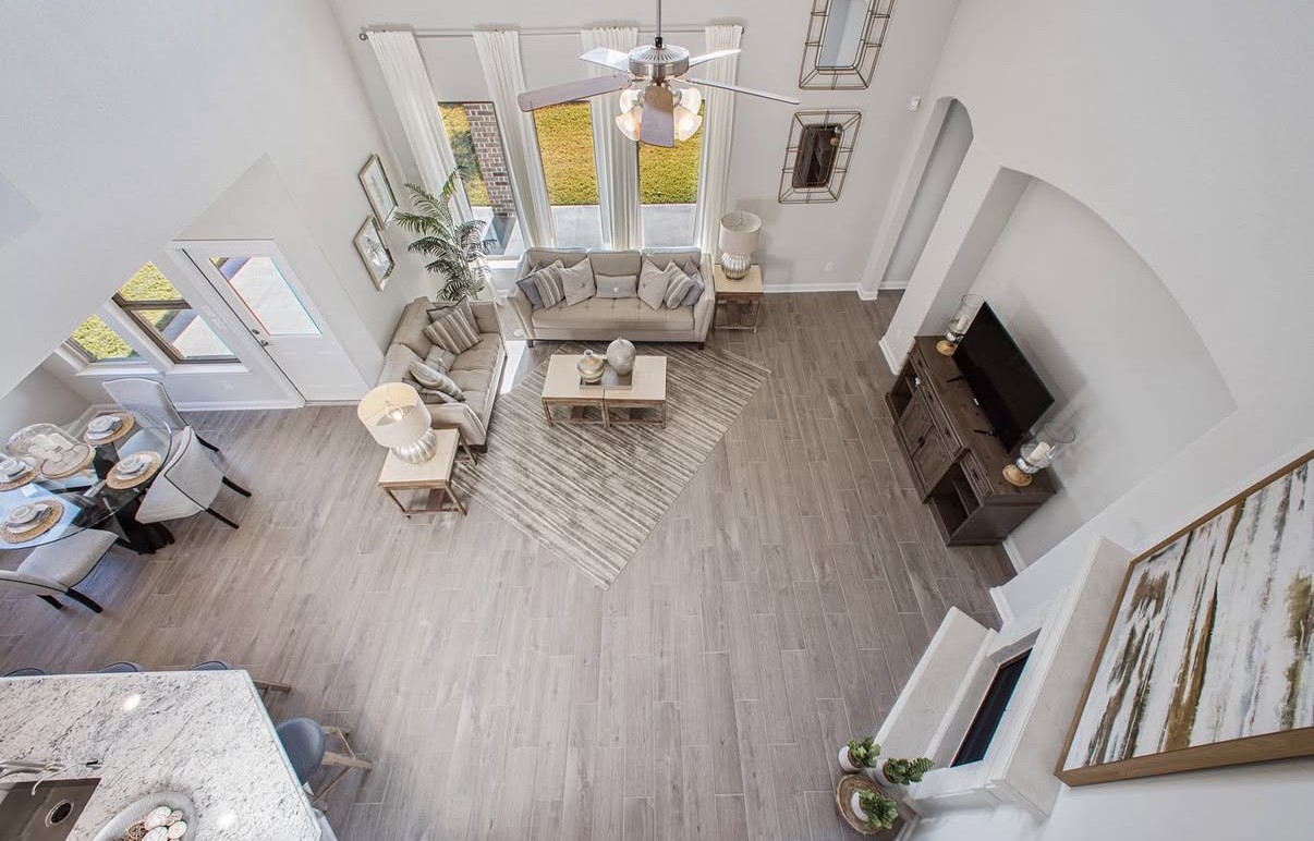 Bright and spacious living area with high ceilings and an open layout connecting to the dining space. Large windows offer abundant natural light and a view of the backyard. Arched niches make placing you furniture quite easy.
