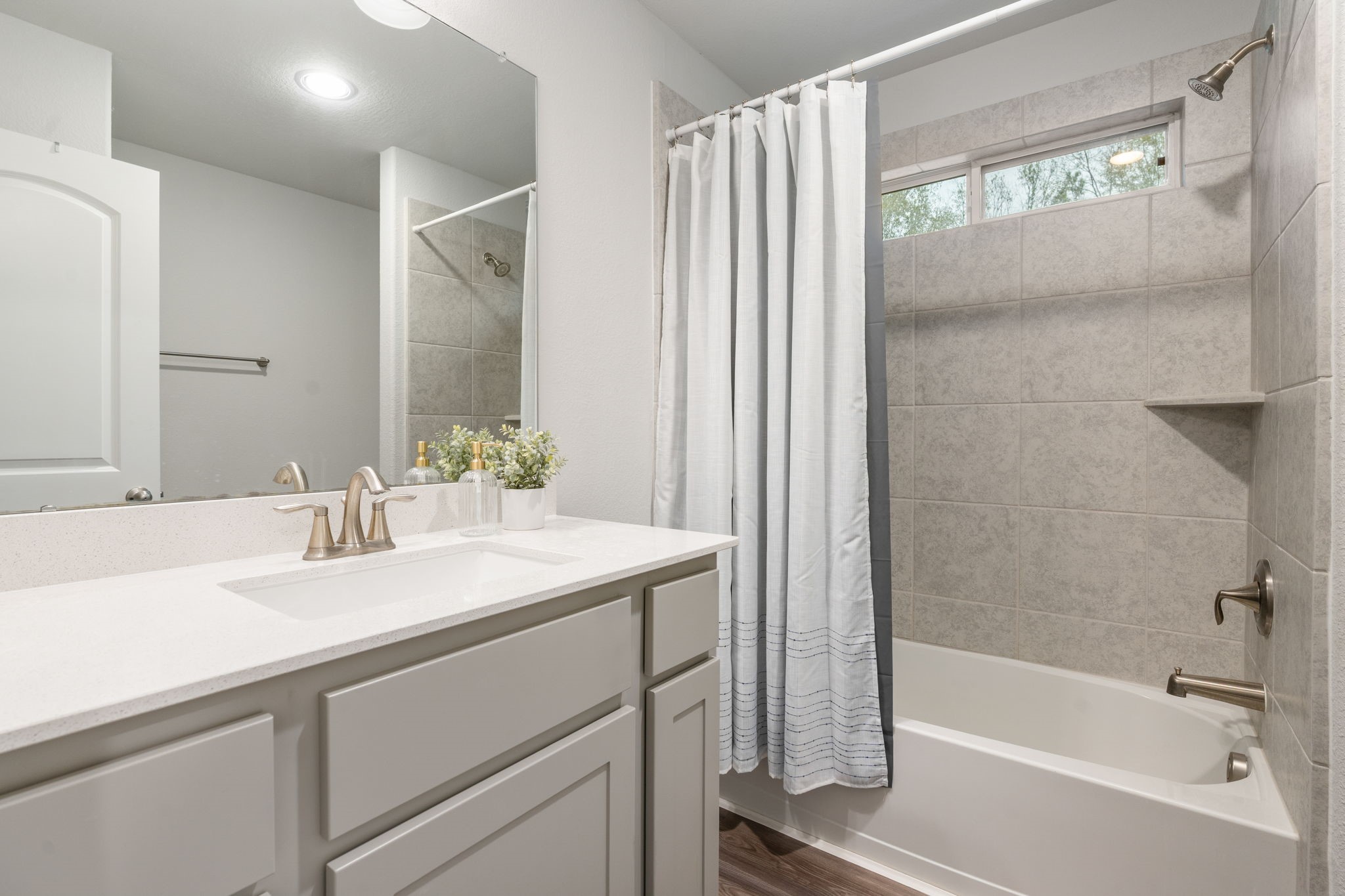 beautiful quartz counters and shower/tub combo.