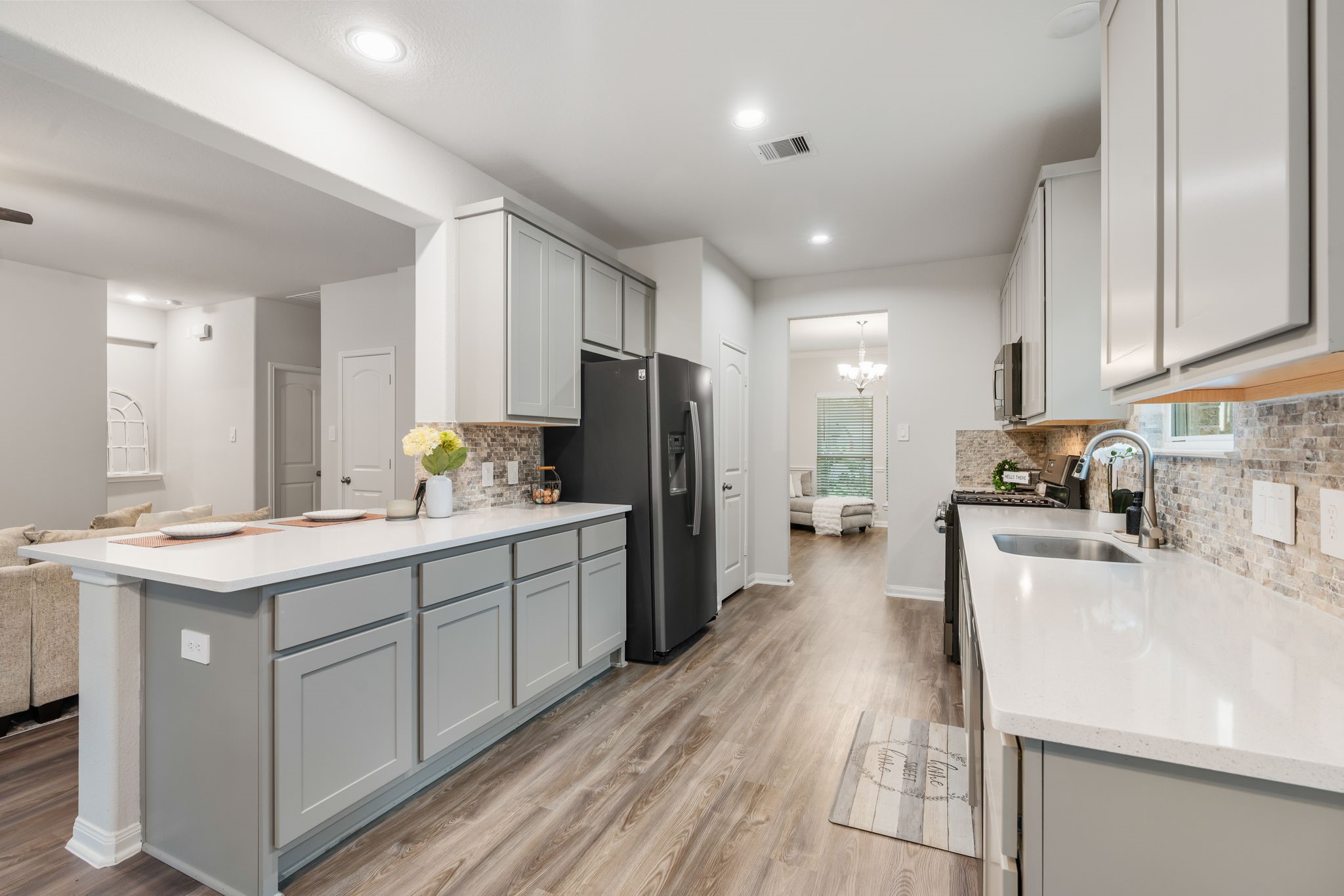 Kitchen features slate slate appliances, quartz countertops and designer backsplash.