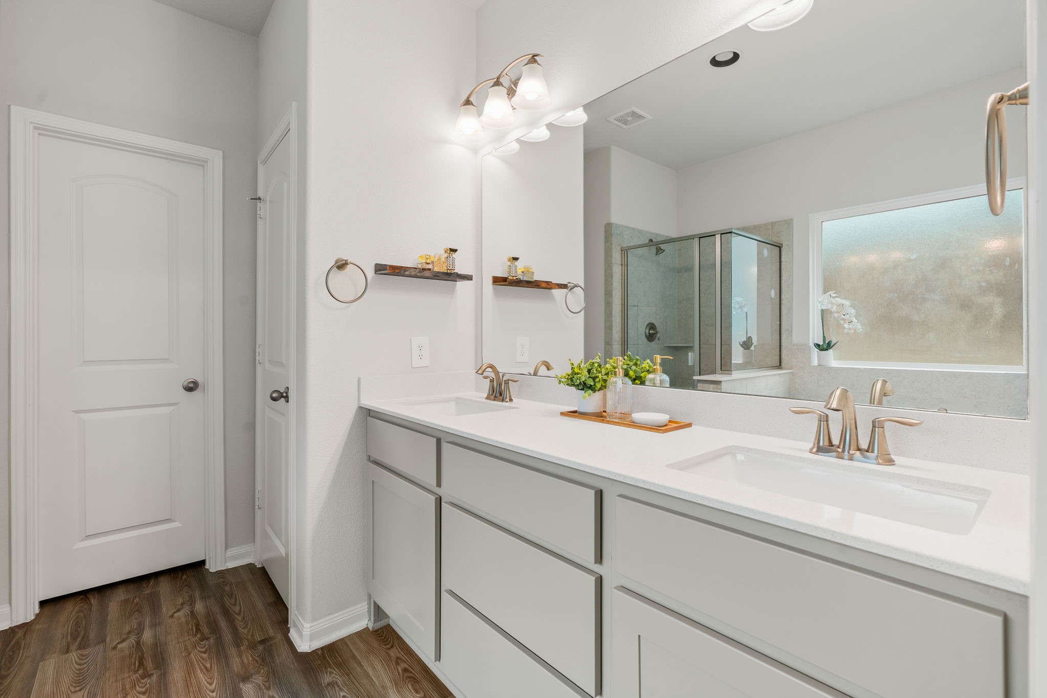 Double sinks and a walk-in closet with shelving.
