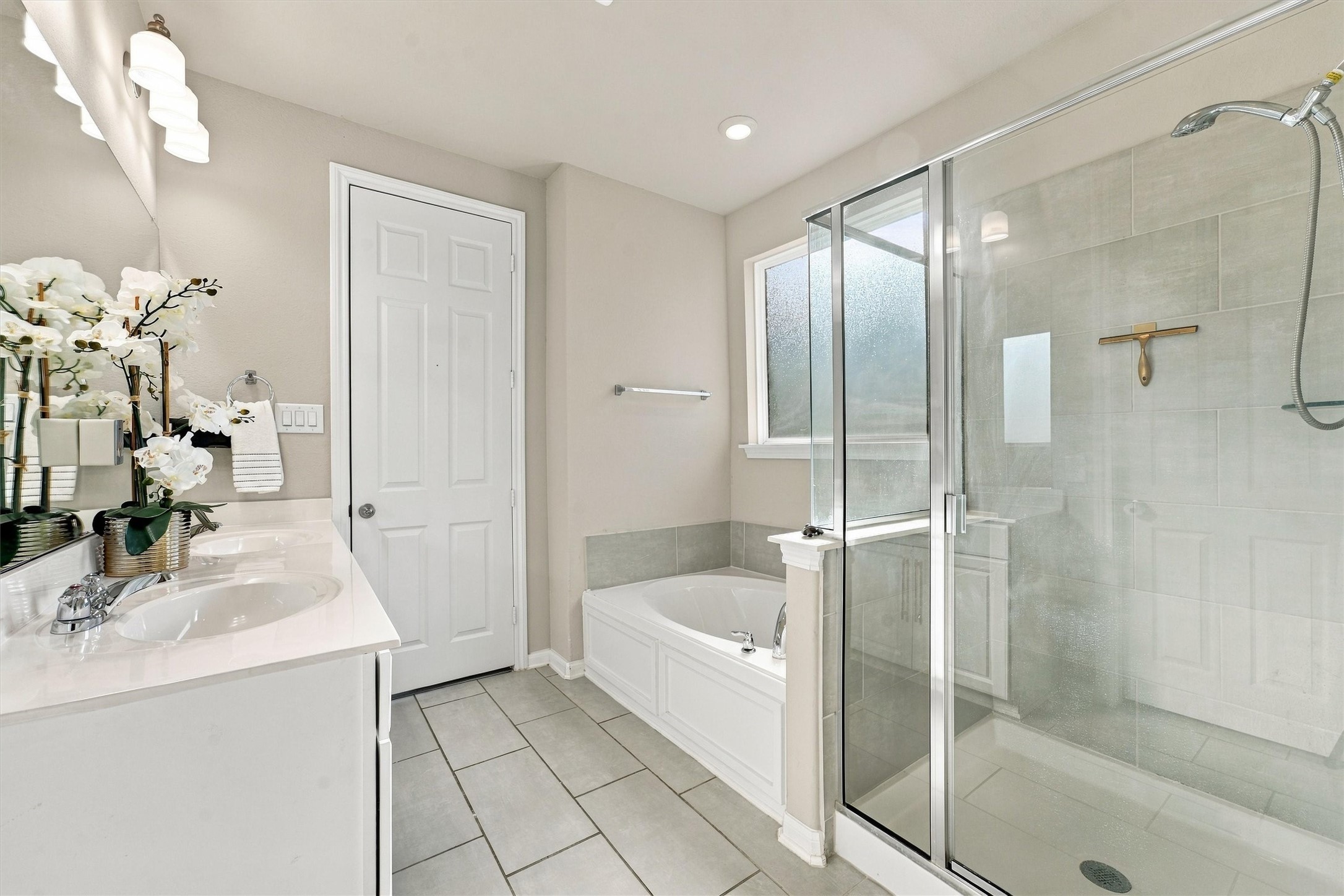 Primary bath brings together dual sinks, a soaking tub, and a separate glass-enclosed shower for everyday comfort