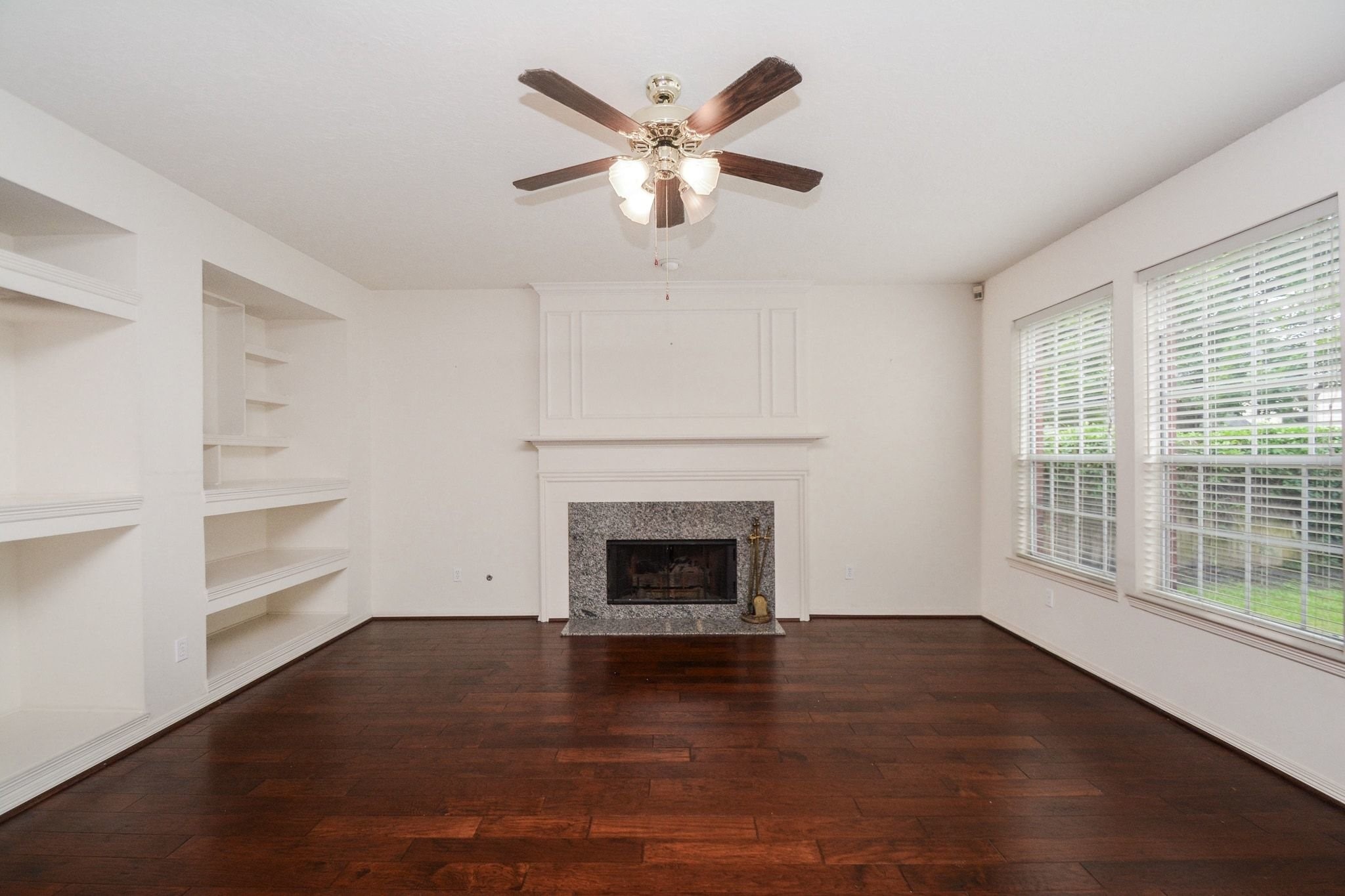 Den with hardwood floors and custom shelving