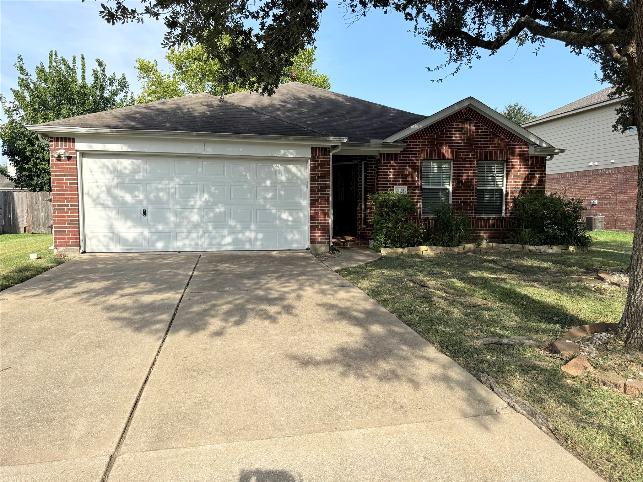 Charming brick home with a spacious driveway and inviting front yard, perfect for creating lasting memories.