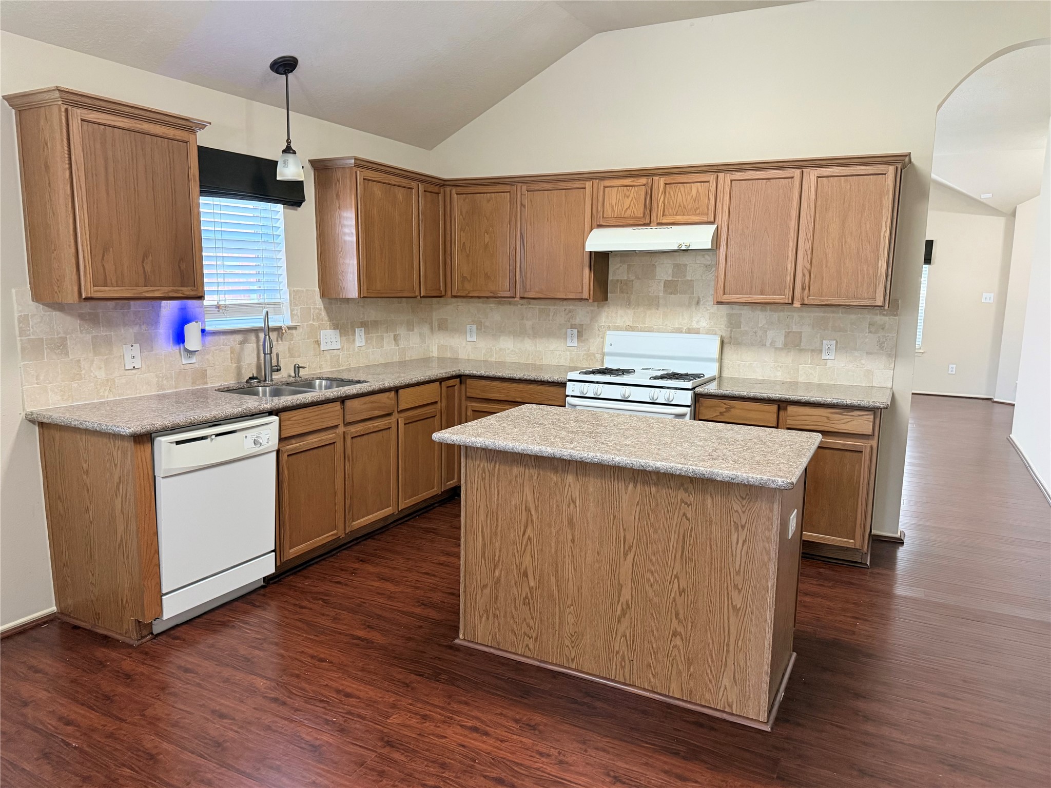 Spacious kitchen with warm wood cabinetry, a central island, and modern appliances, perfect for family gatherings and meal prep.