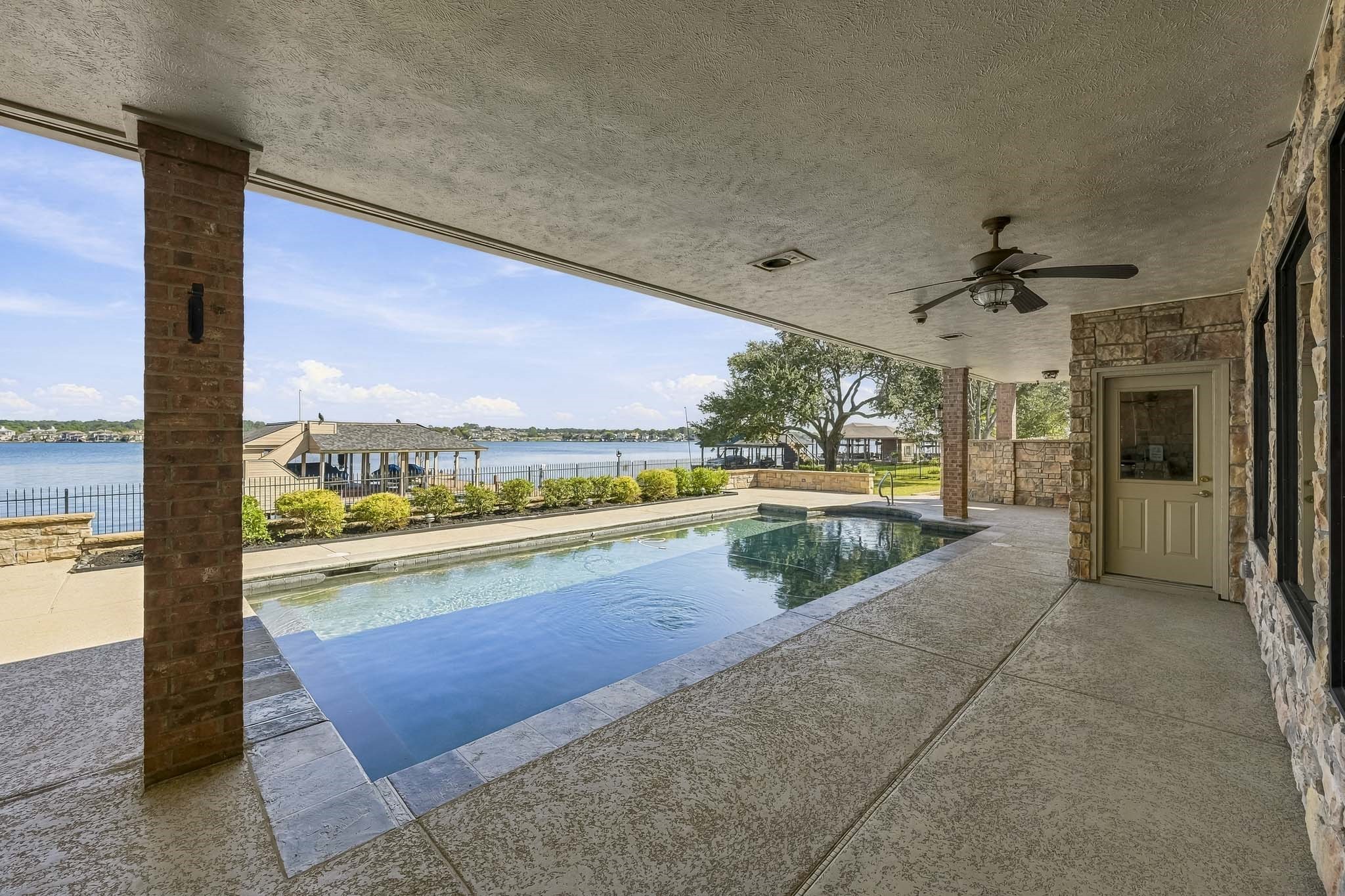 Your own waterfront retreat! Relax beside the sparkling pool or unwind beneath the expansive covered patio while taking in panoramic Lake Conroe views.