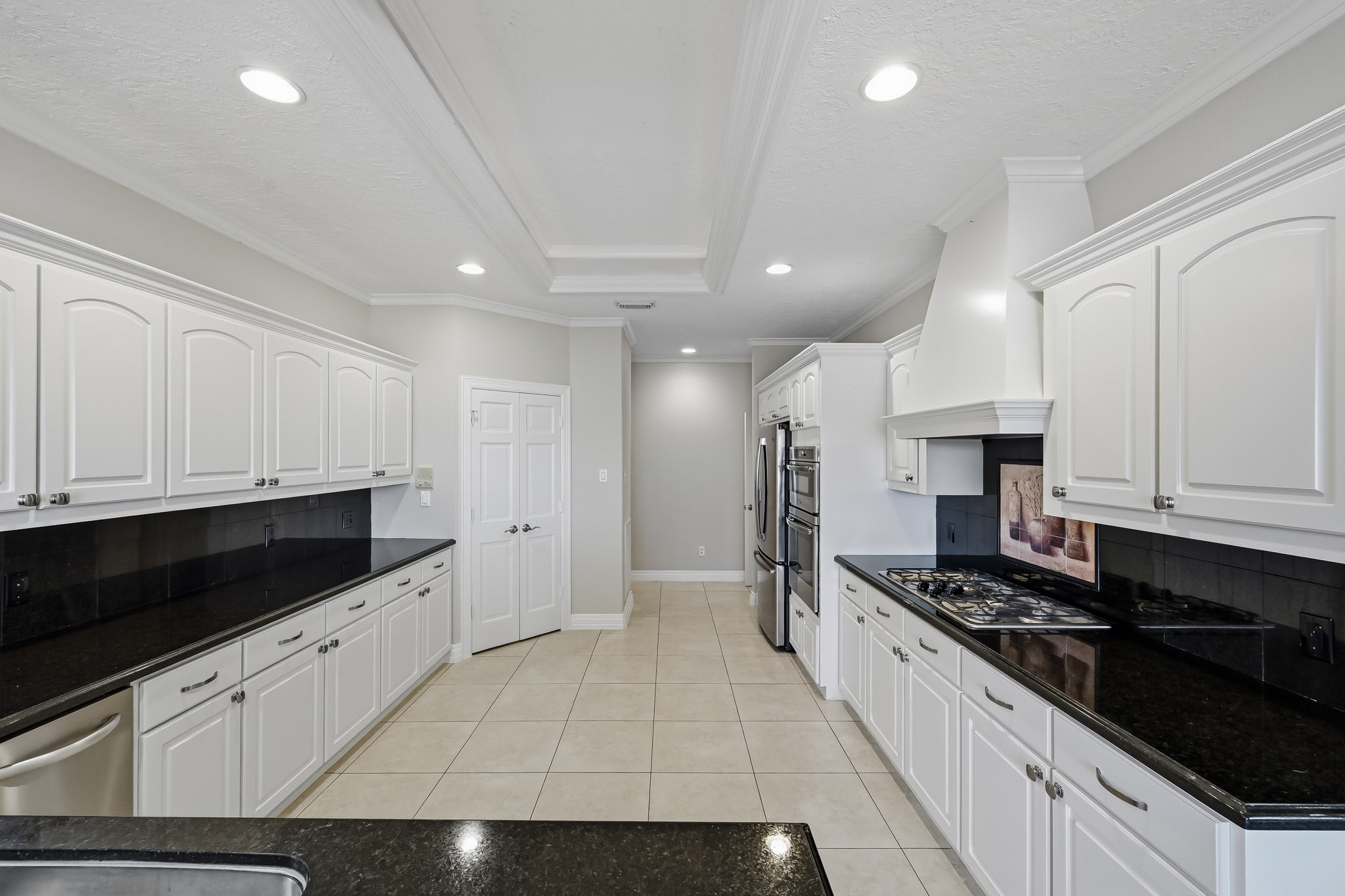 A gas cooktop, custom vent hood and extensive cabinetry make this kitchen as practical as it is inviting!