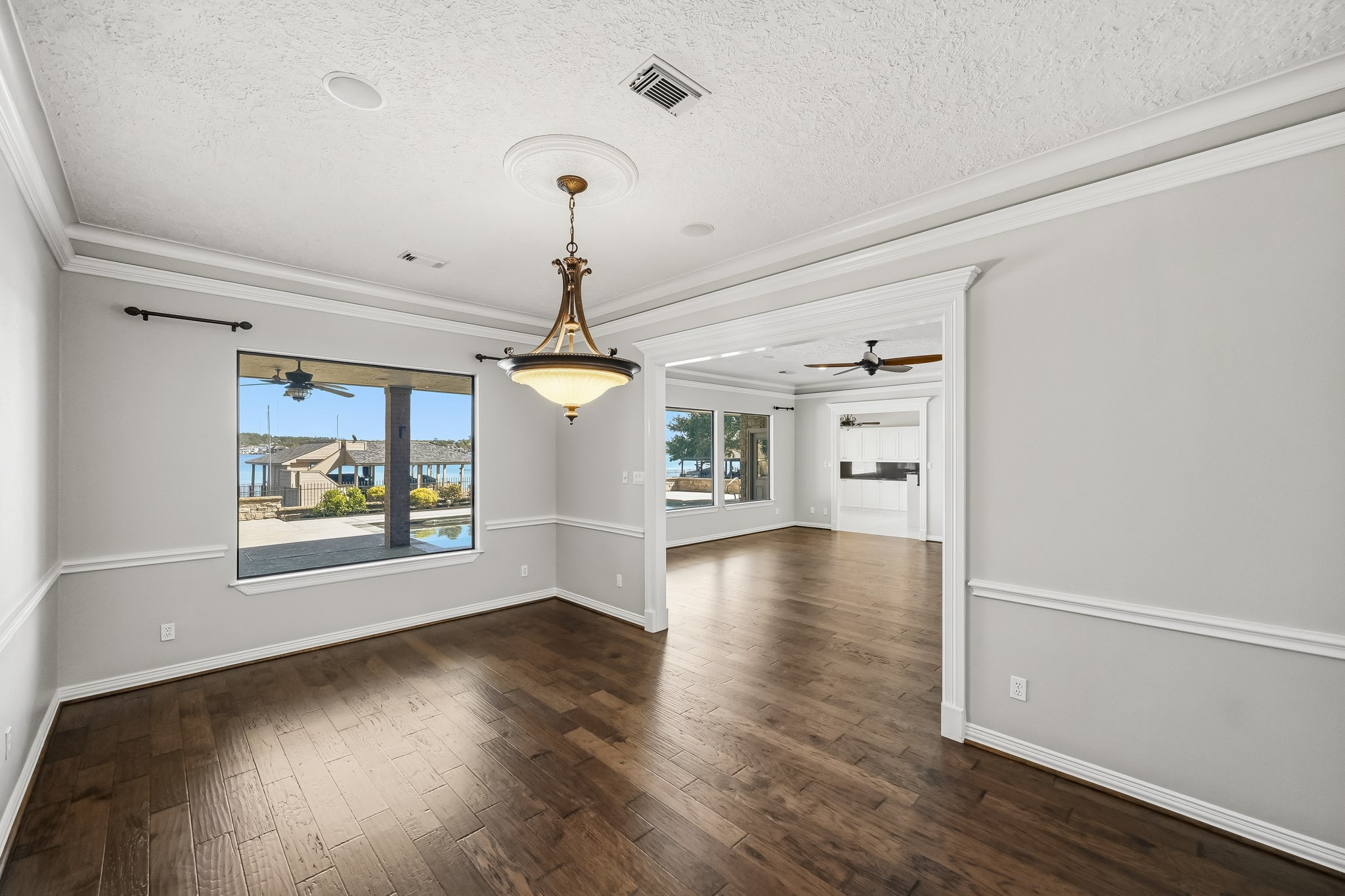Dine with a view! A large window overlooks the pool and Lake Conroe, while a wide opening provides easy access to the living room.