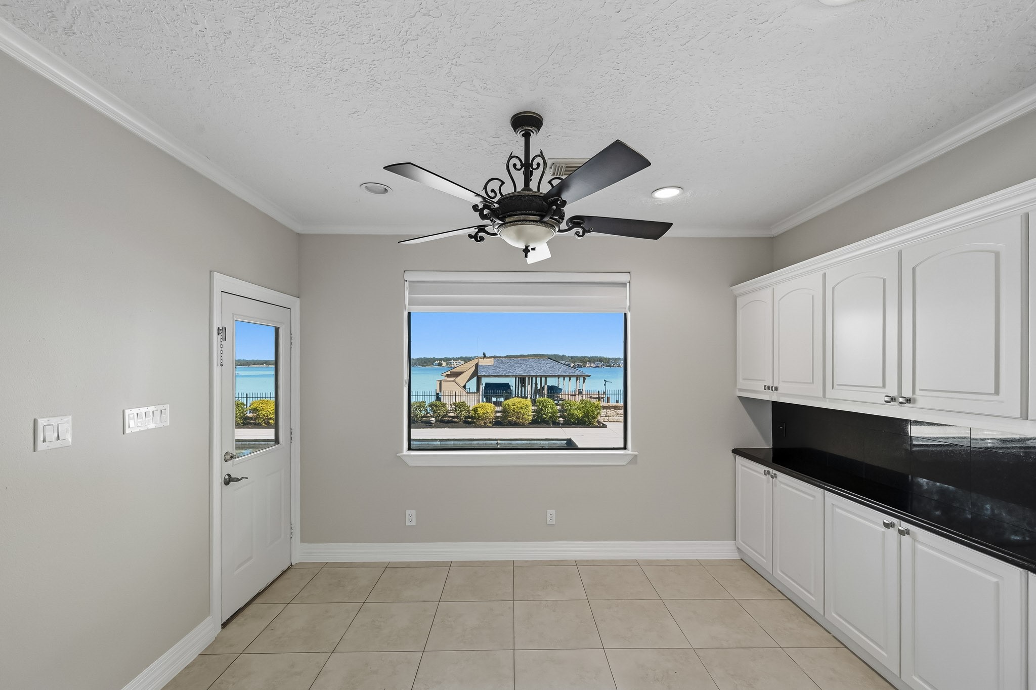 Start your mornings with beautiful Lake Conroe views! This bright breakfast area offers additional storage cabinetry, pool and boathouse views and direct patio access.