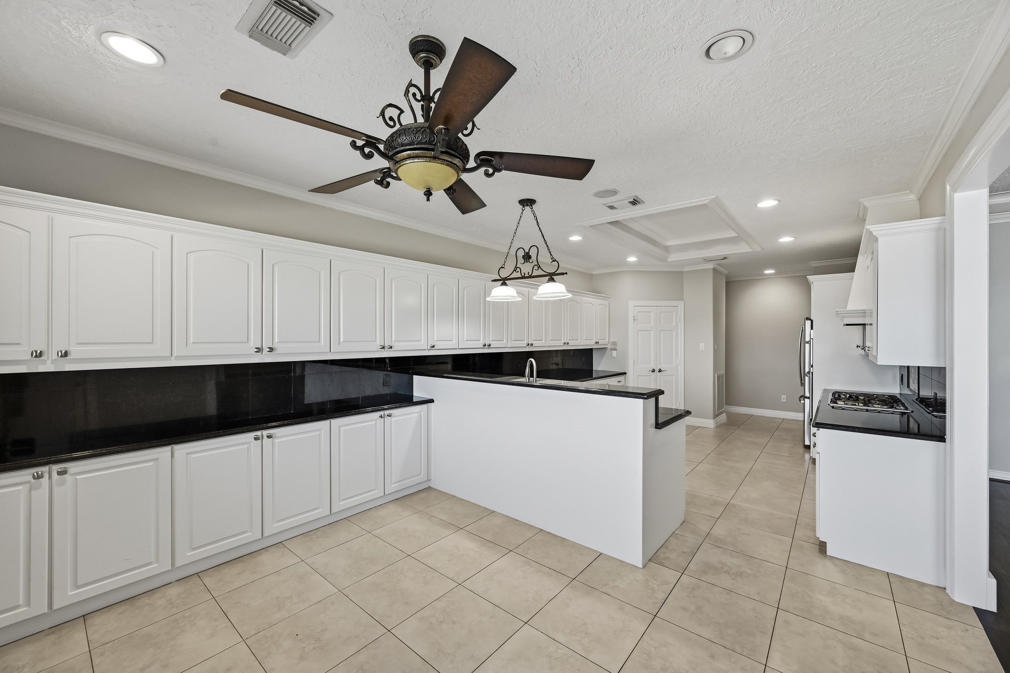 Designed for functionality, the kitchen features expansive counter space, a prep sink, recessed lighting and attractive architectural ceiling details.