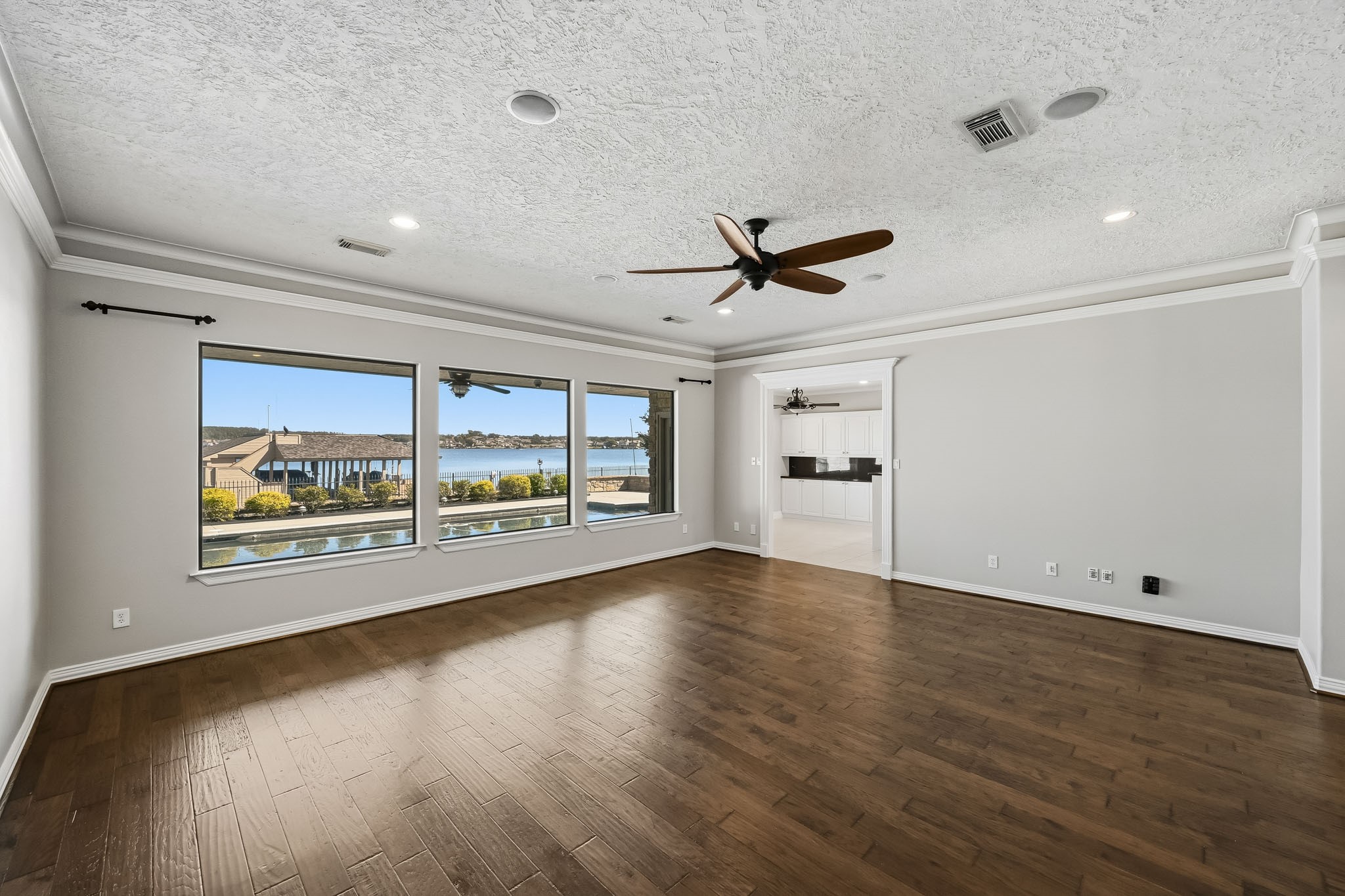 WOW! Three oversized picture windows frame spectacular views of the sparkling pool and Lake Conroe, bringing waterfront beauty indoors!