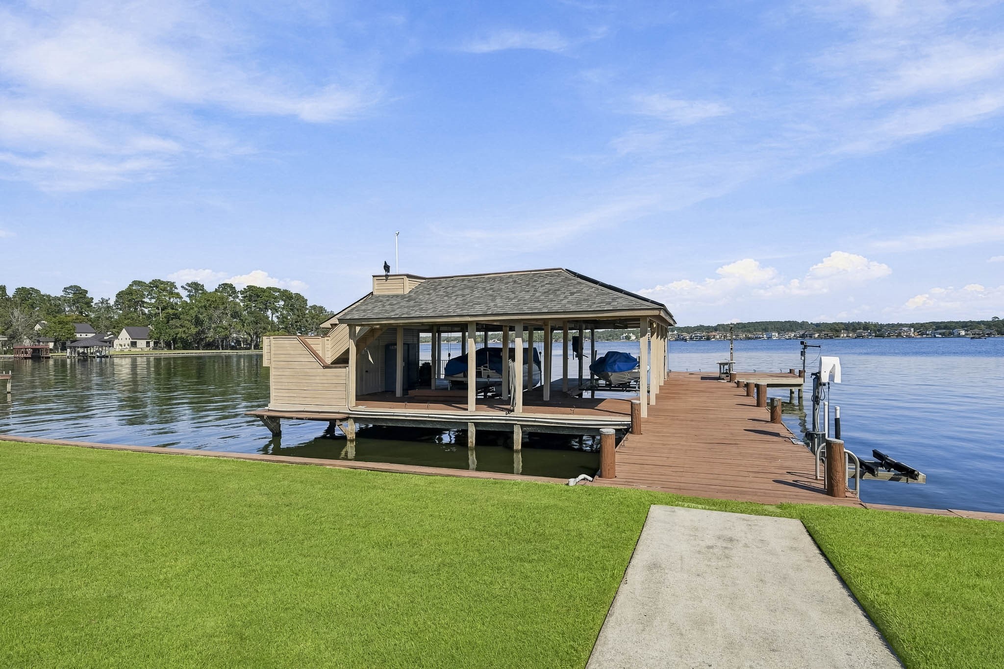 Exceptional waterfront living! This impressive two-story boathouse features two covered boat slips, expansive decking and direct access to the open waters of Lake Conroe.
